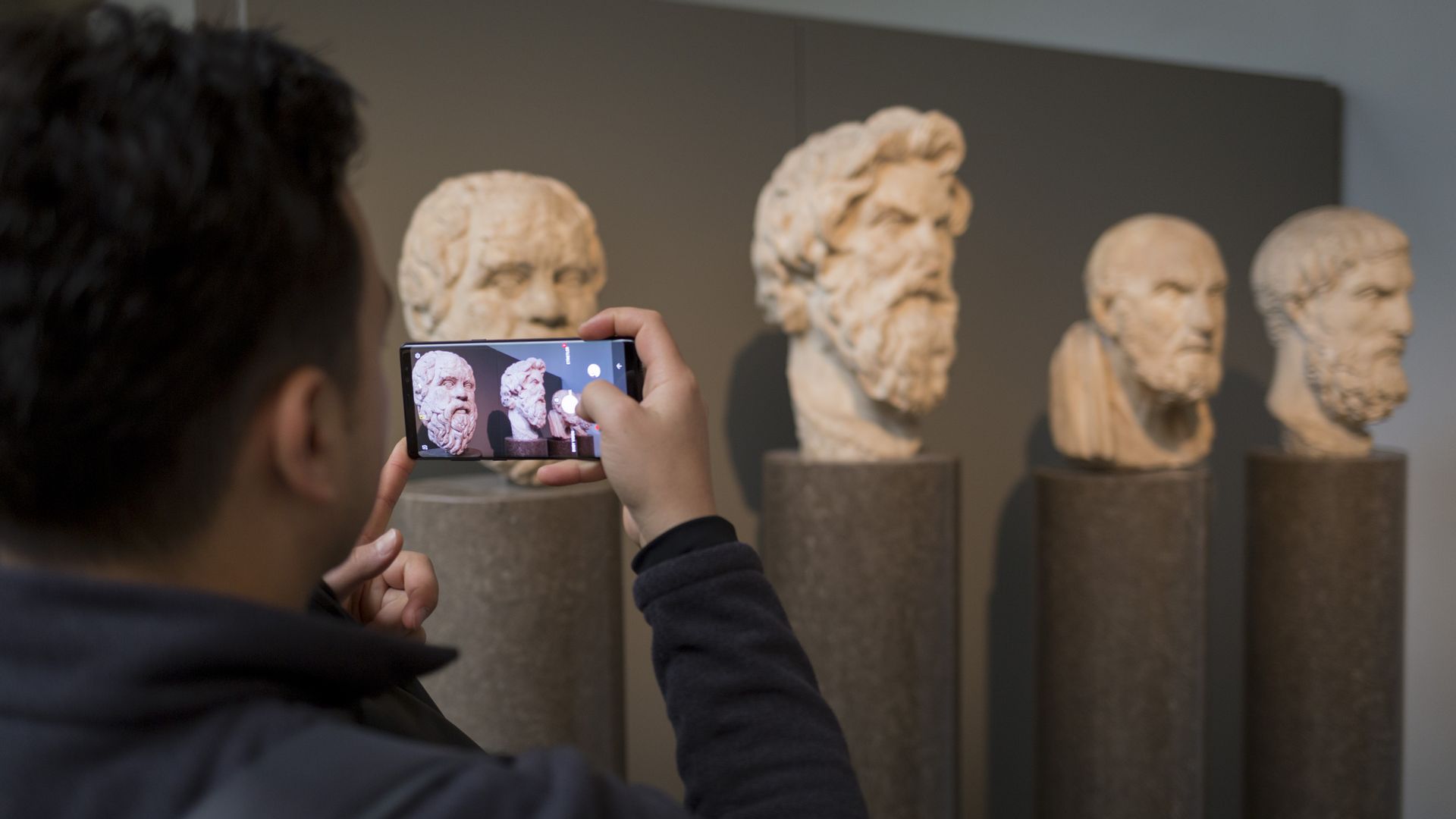 A visitor to the British museum takes a photo on his smartphone.