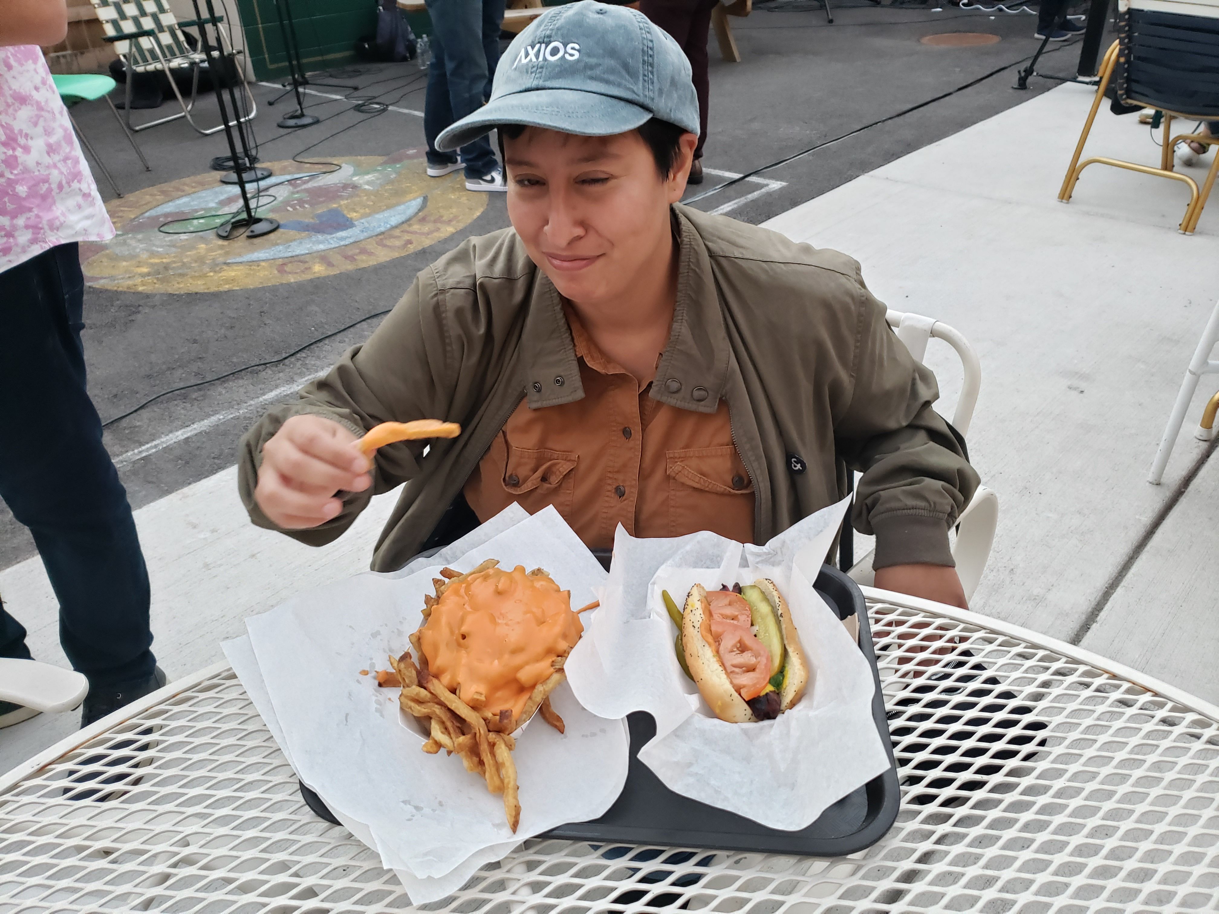 Woman eating hot dog and cheese fries
