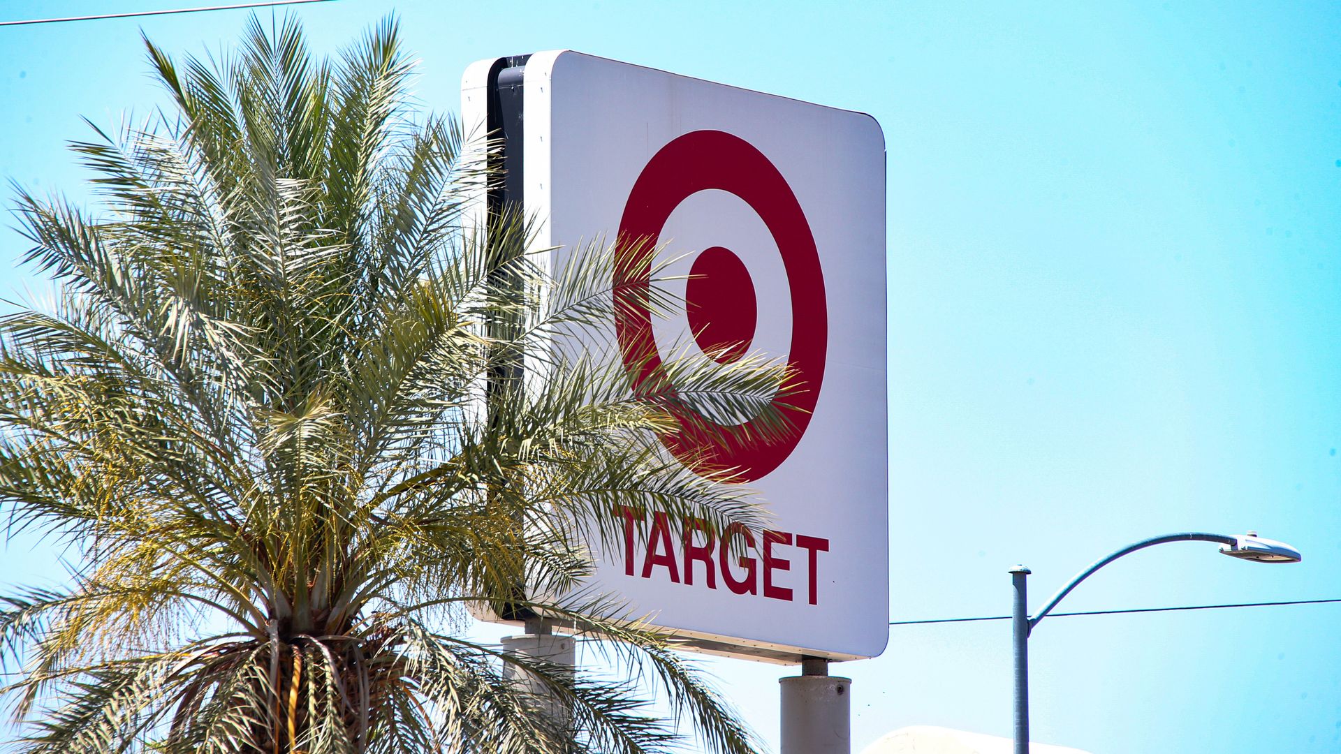 A Target Corporation logo is displayed on a sign near their retail store with palm trees