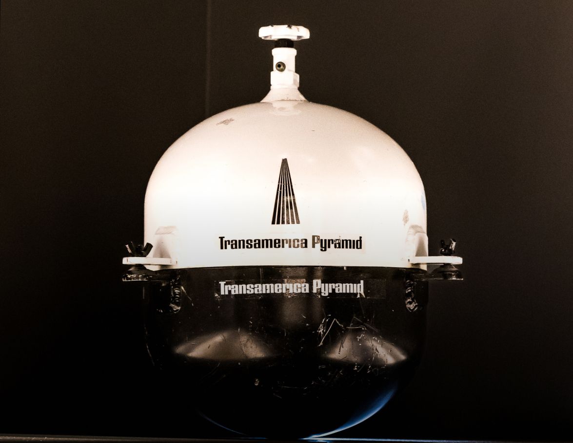 Photo of a white and silver cylindrical steel time capsule