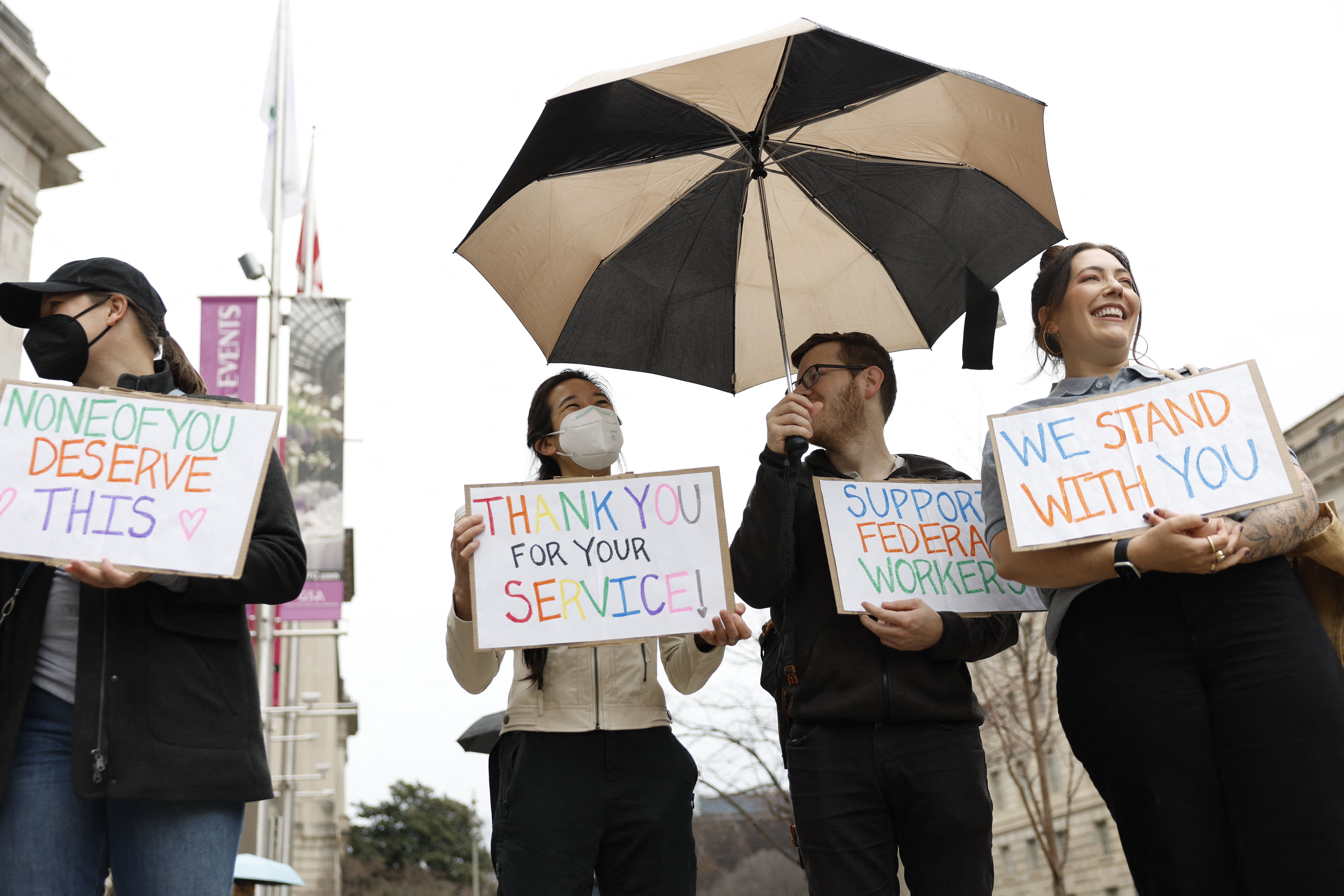 Supporters hold signs of support outside USAID.