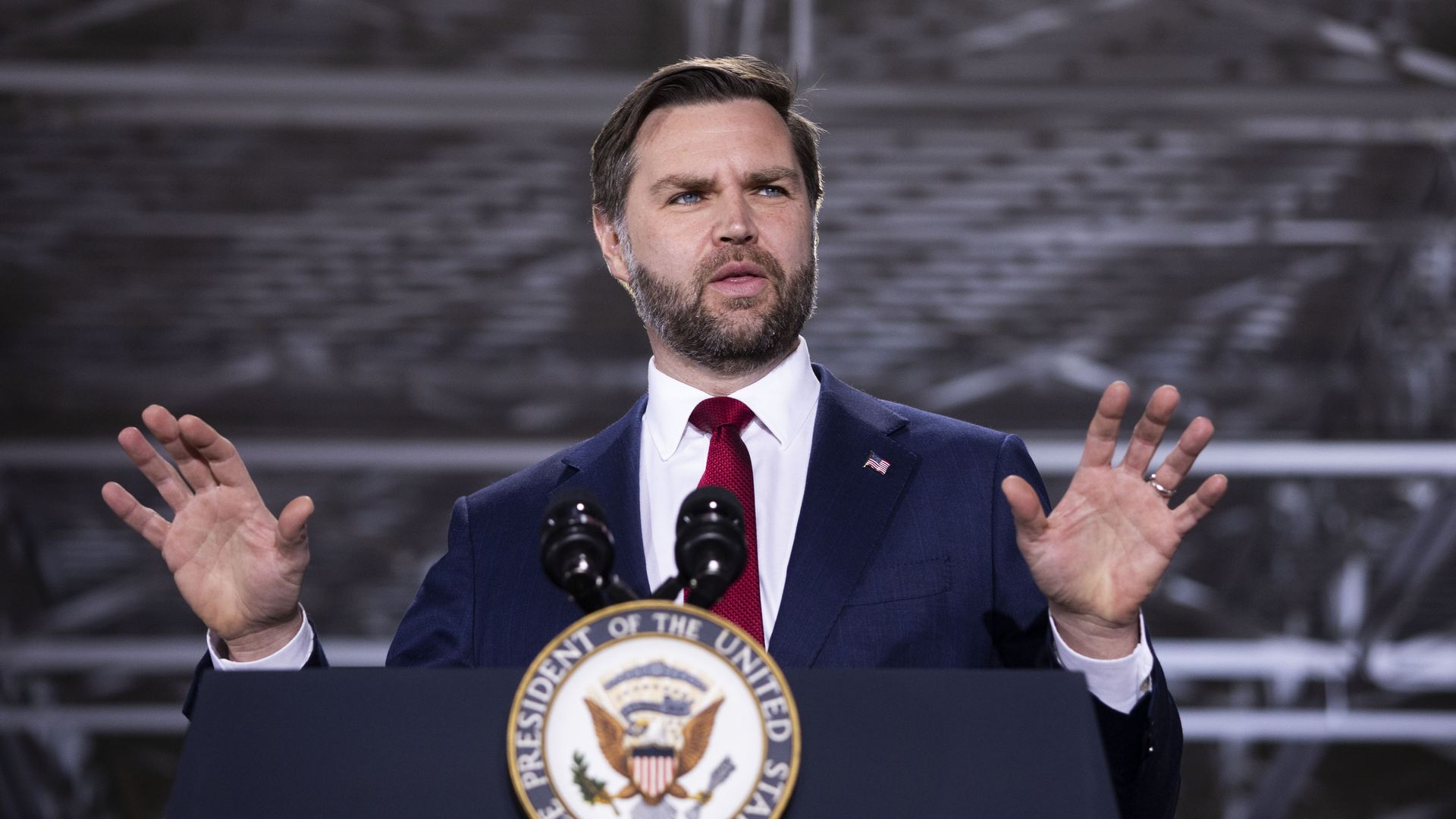Vice President JD Vance speaks at a podium inside an industrial facility in Auburn Hills, Michigan.