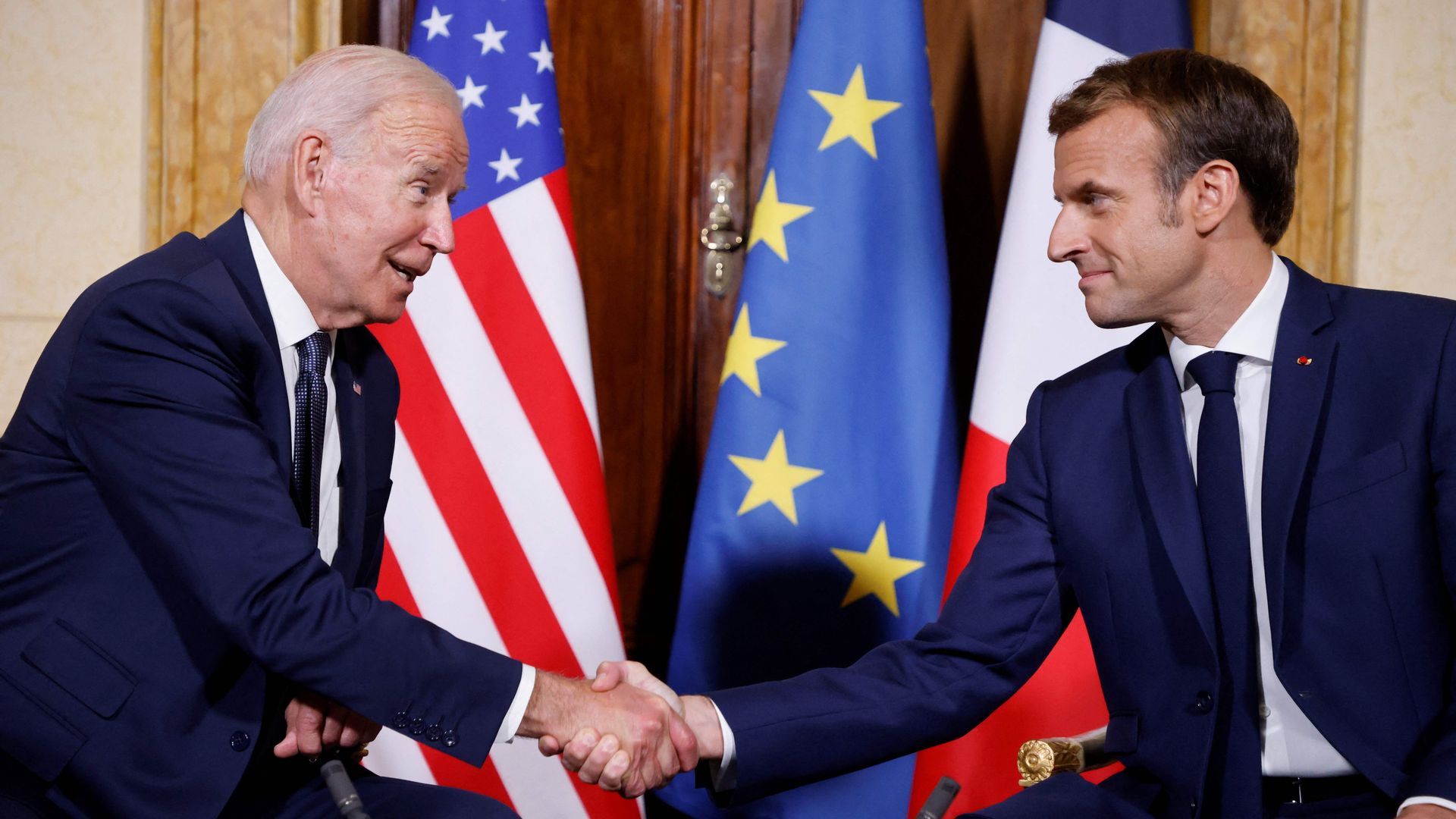 Biden shaking hands with Macron