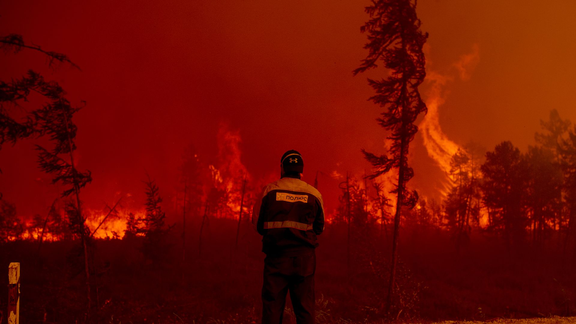 Firefighter stands in front of a wildfire in Sakha, Russia in 2021.