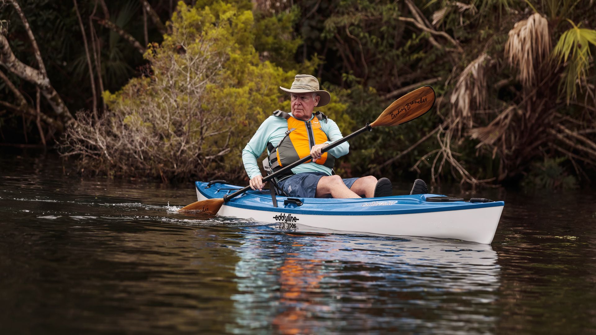 A man in a kayak on a river. 