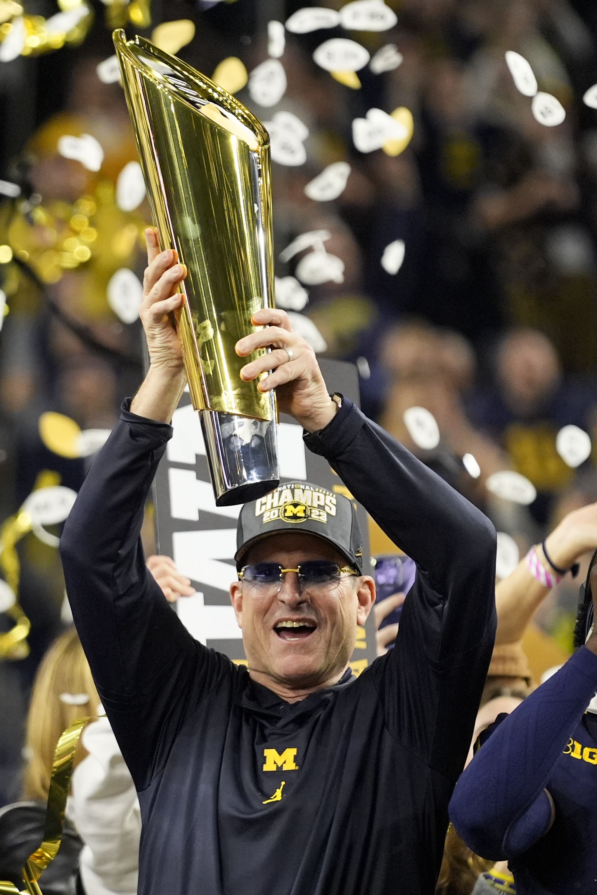 Michigan head coach Jim Harbaugh celebrates with the trophy after their win against Washington in the national championship NCAA College Football Playoff game.