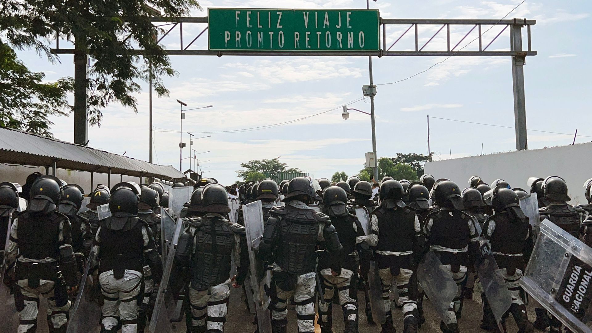 Dozens of military members in full gear are shown from the back in Mexico 