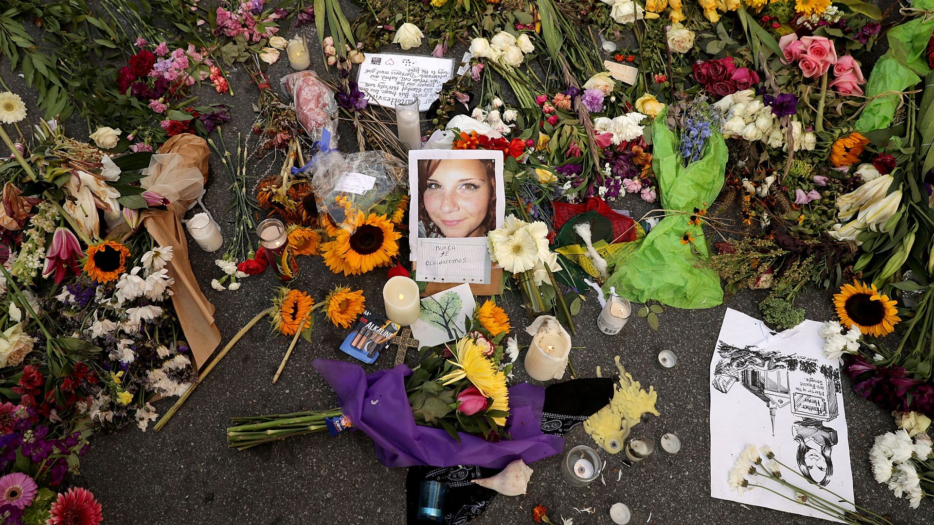 Flowers, candles and chalk-written messages surround a photograph of Heather Heyer on the spot where she was killed and 19 others injured.