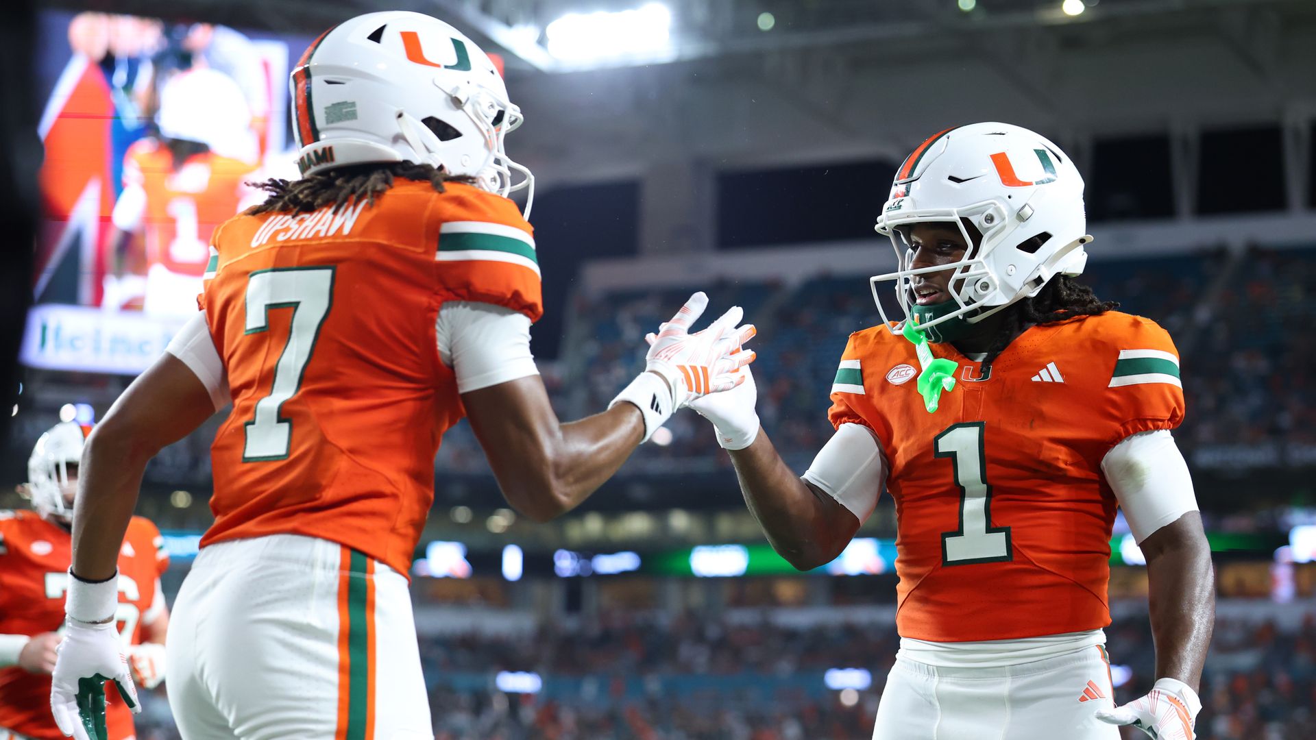 Two UM football players cheering.