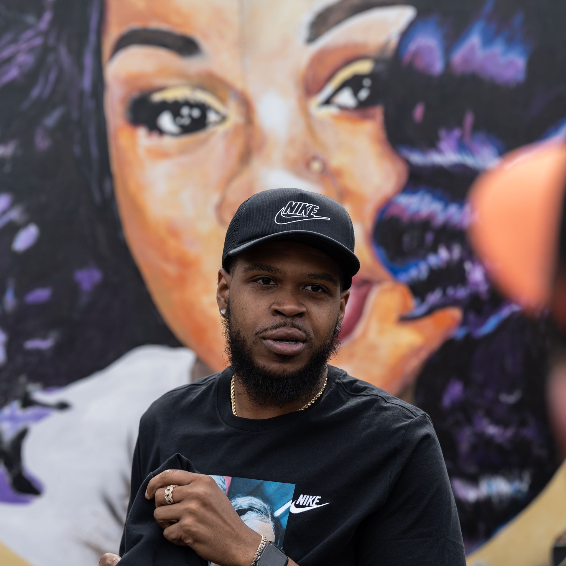 Kenneth Walker, boyfriend of Breonna Taylor, stands in front of a portrait of Taylor during a protest memorial for her in Jefferson Square Park on March 13, 2021 in Louisville, Kentucky.