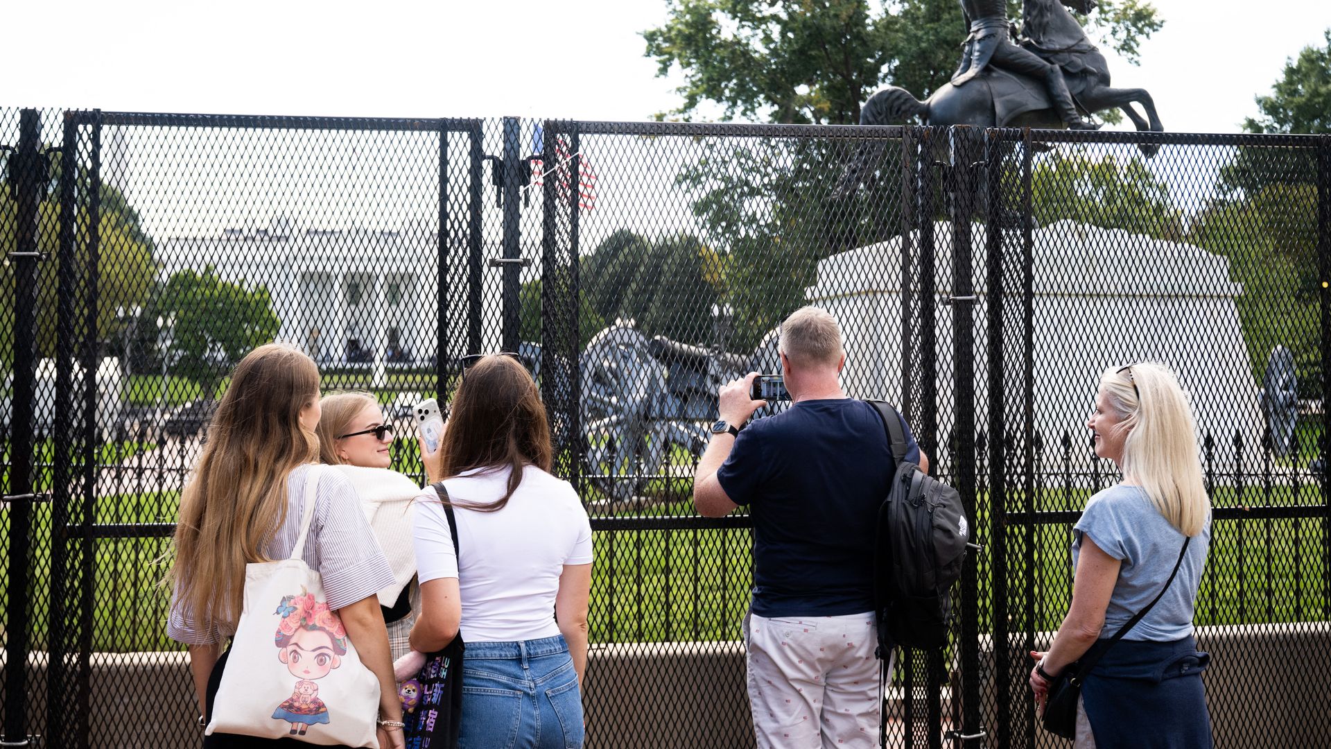 Tourists snap photos outside of the gates by Lafayette Park near the White House.