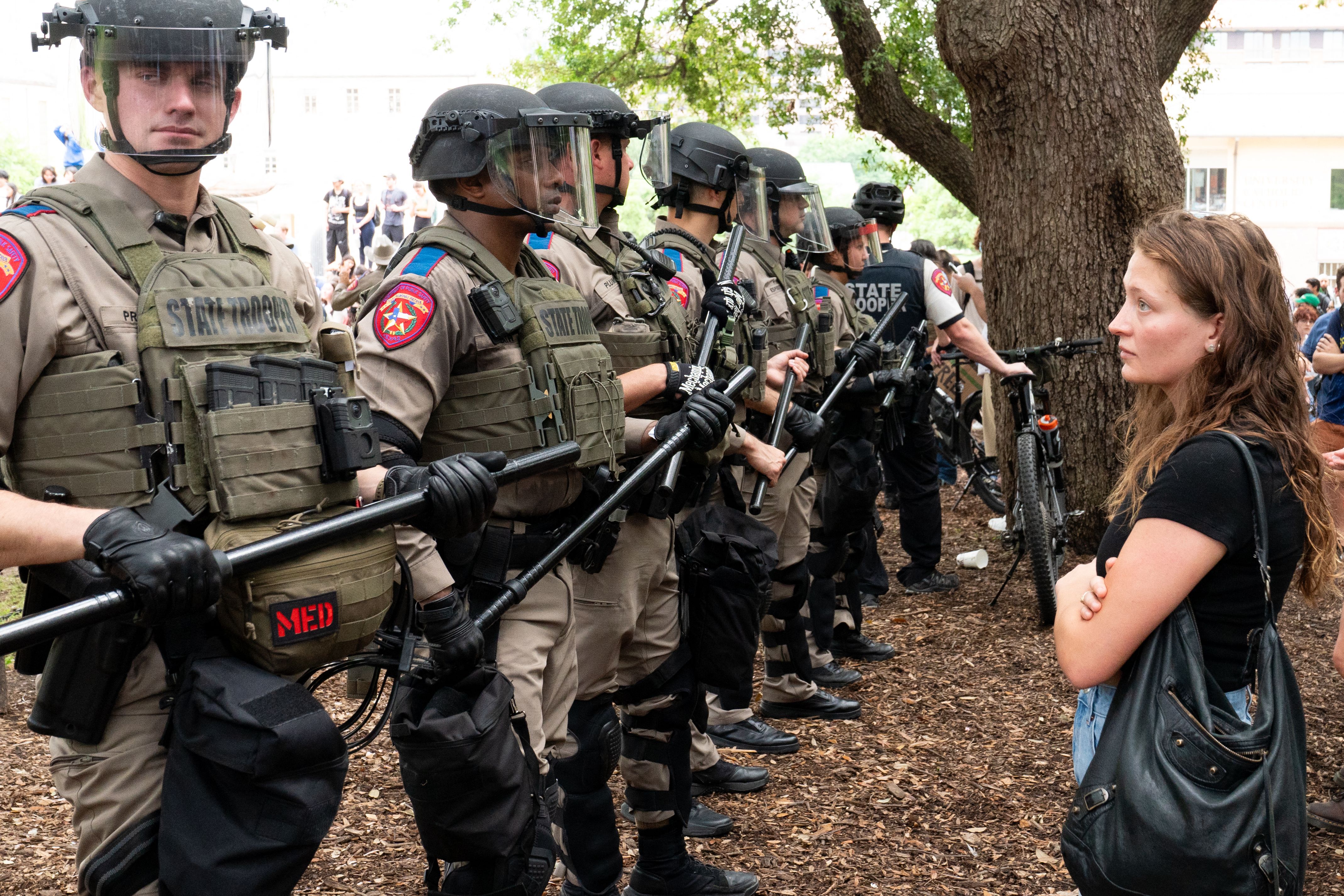 A student quietly stares at a row of Texas State Troopers as pro-Palestinian students protest the Israel-Hamas war on the campus of the University of Texas in Austin, Texas, on April 24, 2024.