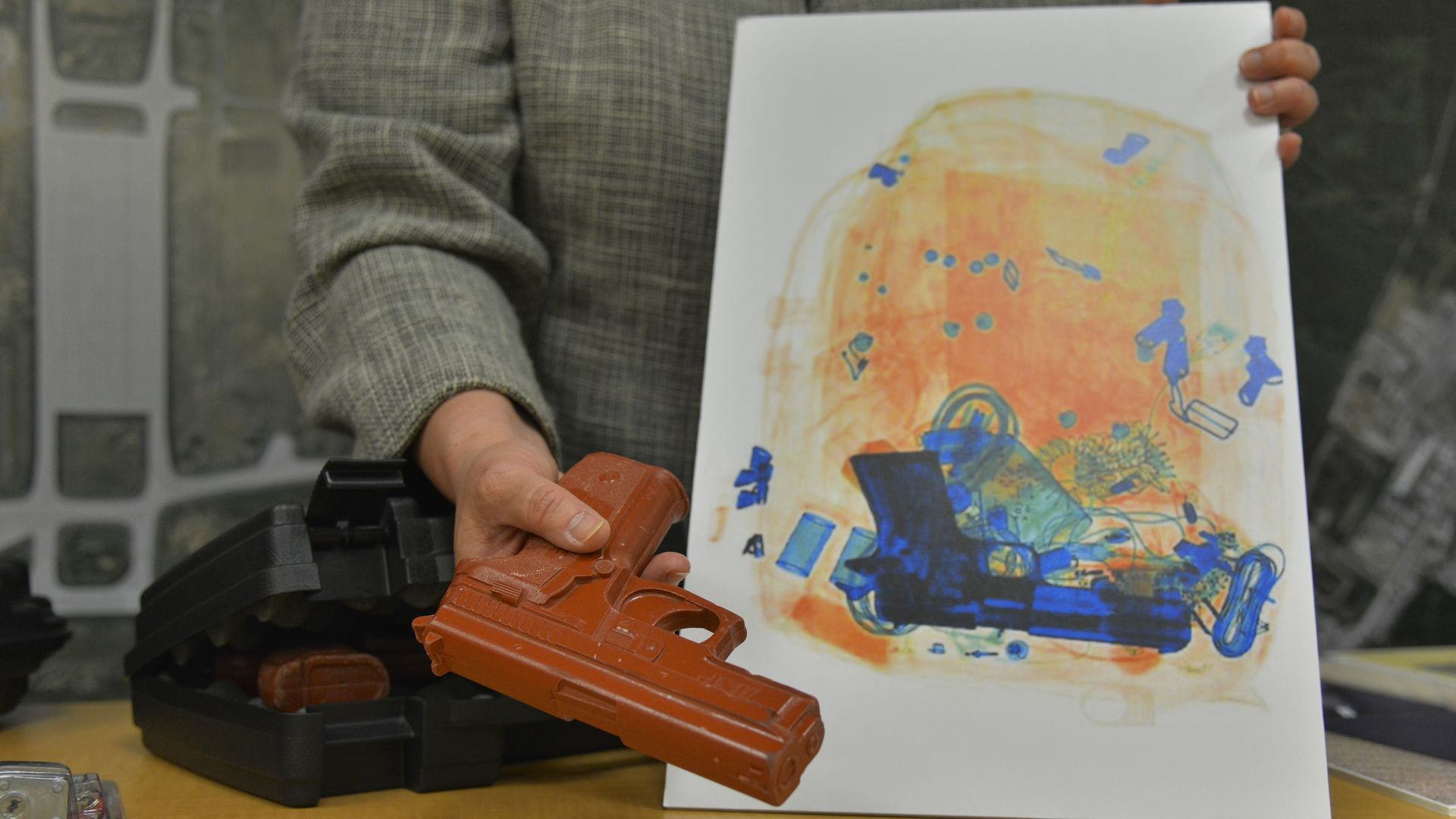 An X-ray image of a gun-shaped object in a bag and someone holding a model gun