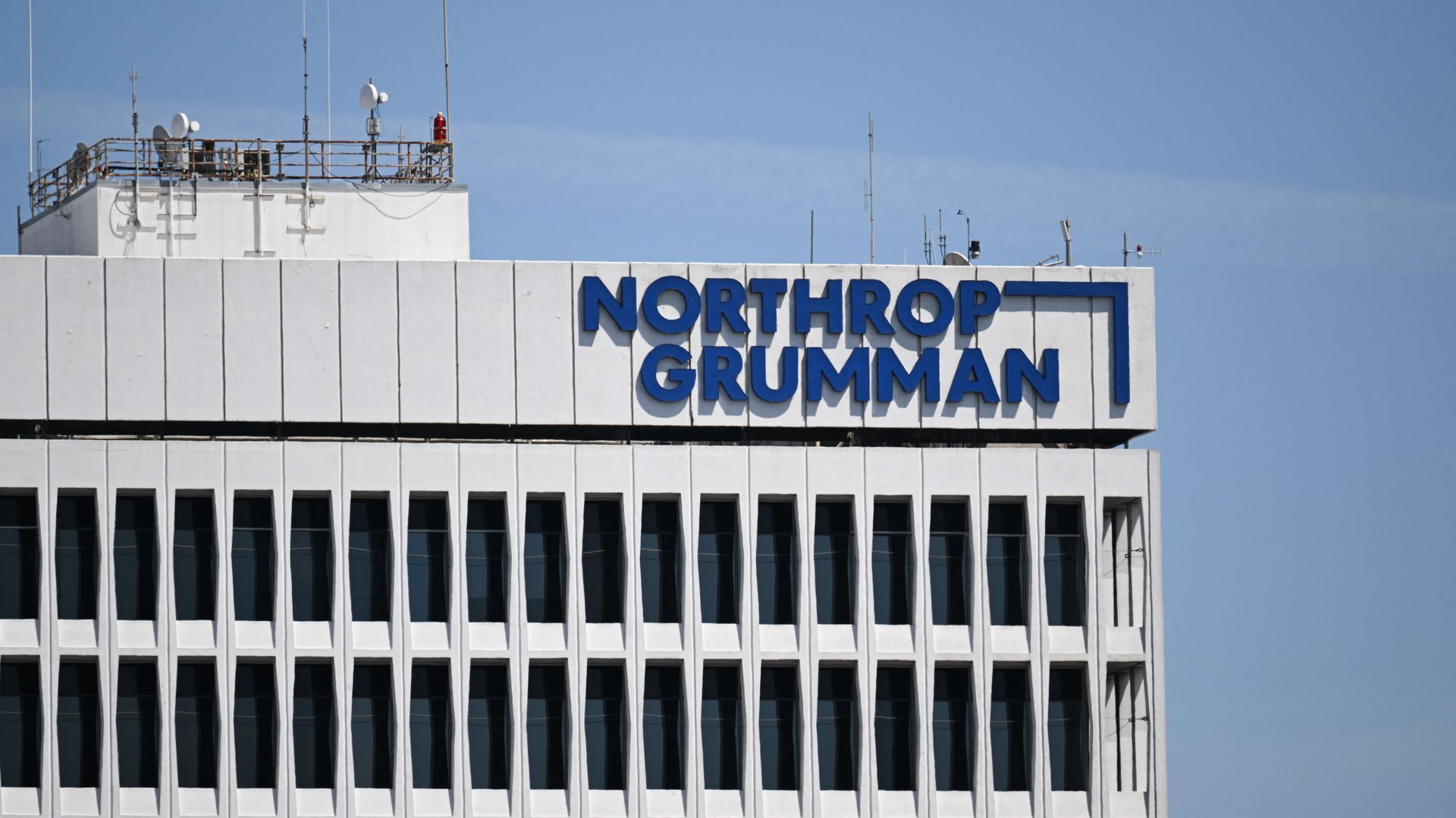 A white multi-story office building with a blue 'NORTHROP GRUMMAN' sign along the top.