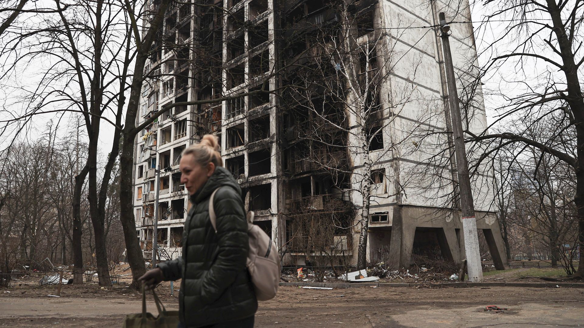 A person walking past a completely destroyed building in Kyiv on March 30 after Russian shelling on parts of the city.