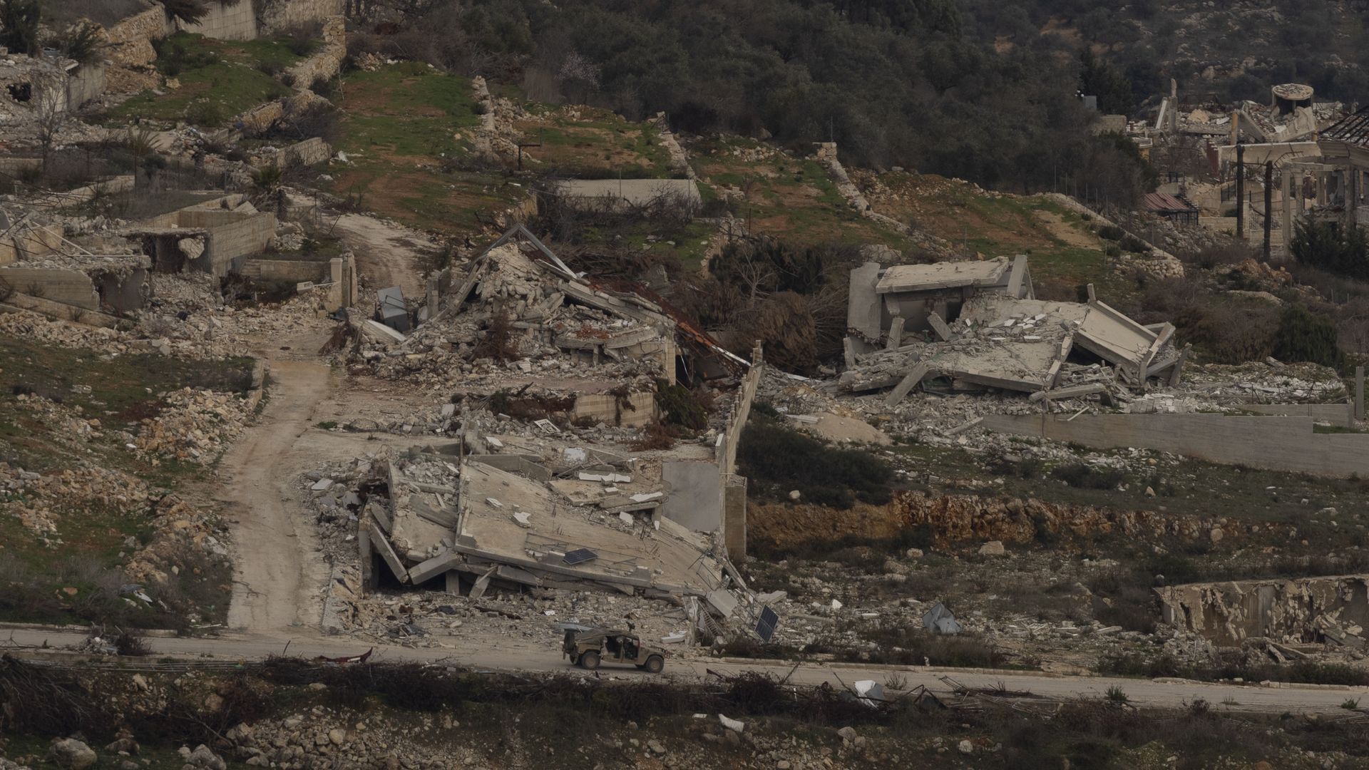 An Israeli army vehicle moves in a village in Southern Lebanon as seen from a position on the Israeli side of the border on January 26, 2025 in Northern Israel, Israel. Israel has said its forces will remain in southern Lebanon after the 60-day withdrawal deadline stipulated in the ceasefire deal.
