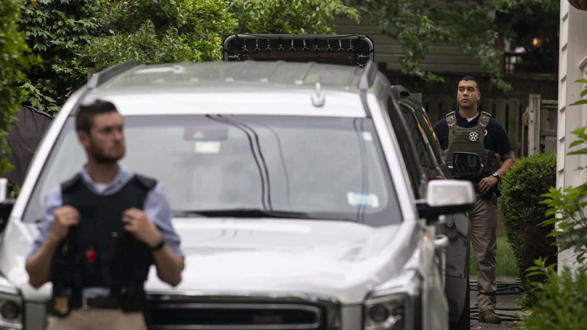 Law enforcement officers stand guard as protesters march past Supreme Court Justice Brett Kavanaugh's home on June 8, 2022