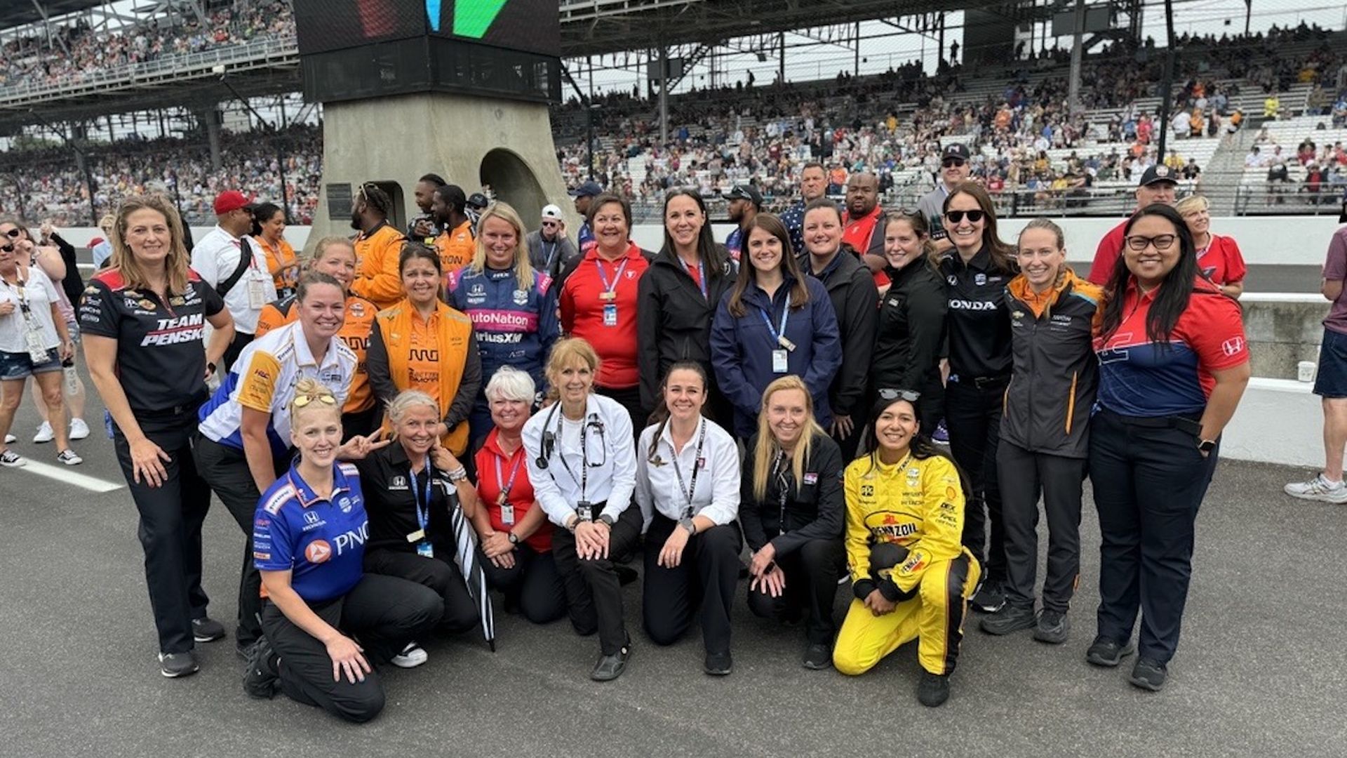 A group of women standing on a racetrack