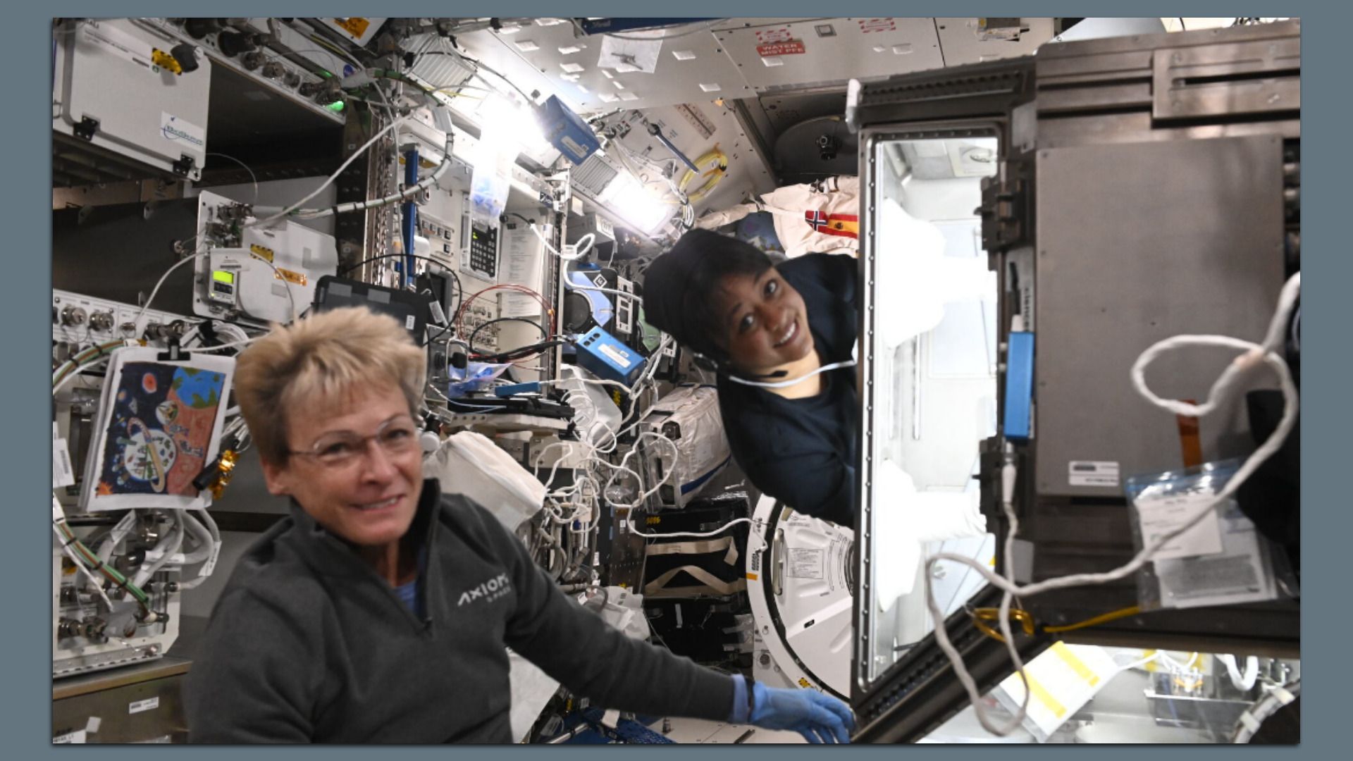 Axiom private astronauts, Commander Peggy Whitson (left) and Mission Specialist, Rayyanah Barnawi (right) pose for a photo in a space ship.