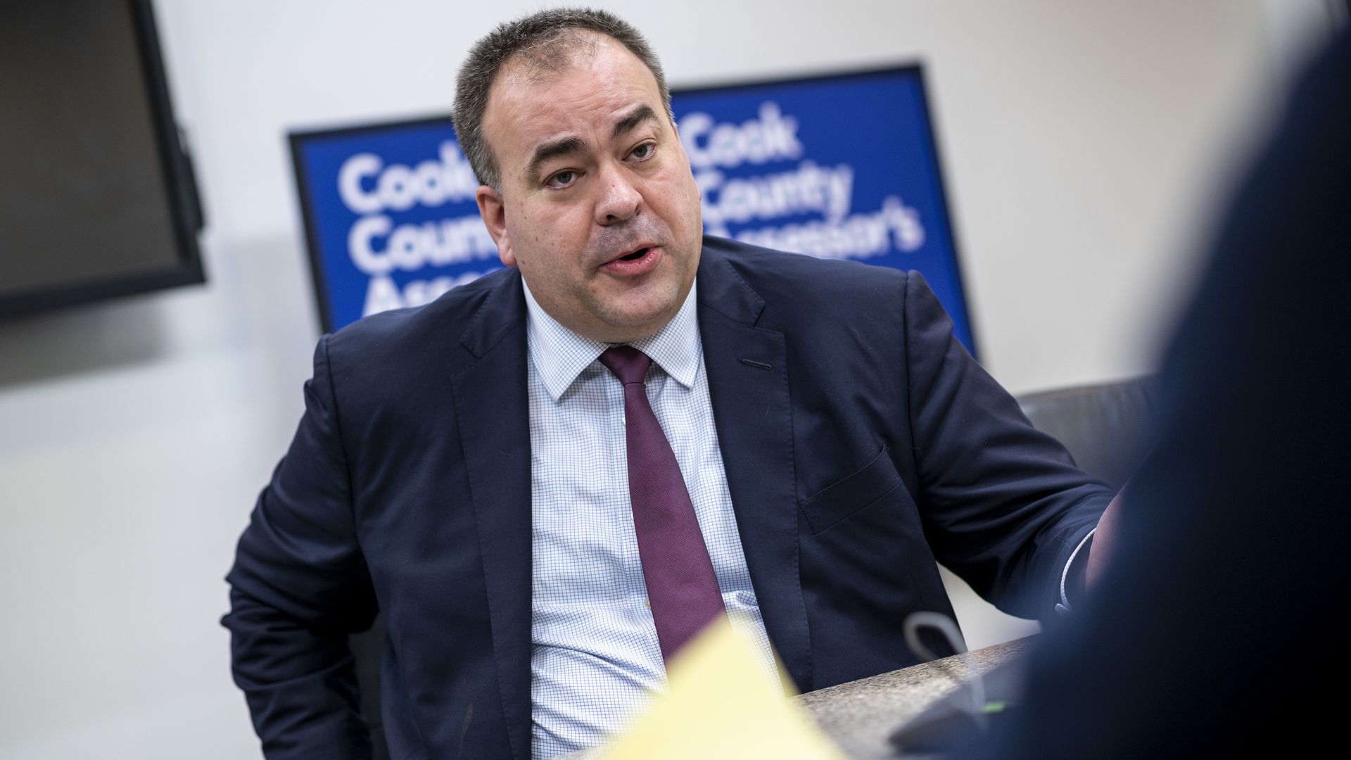 Photo of a man answering questions at a desk.