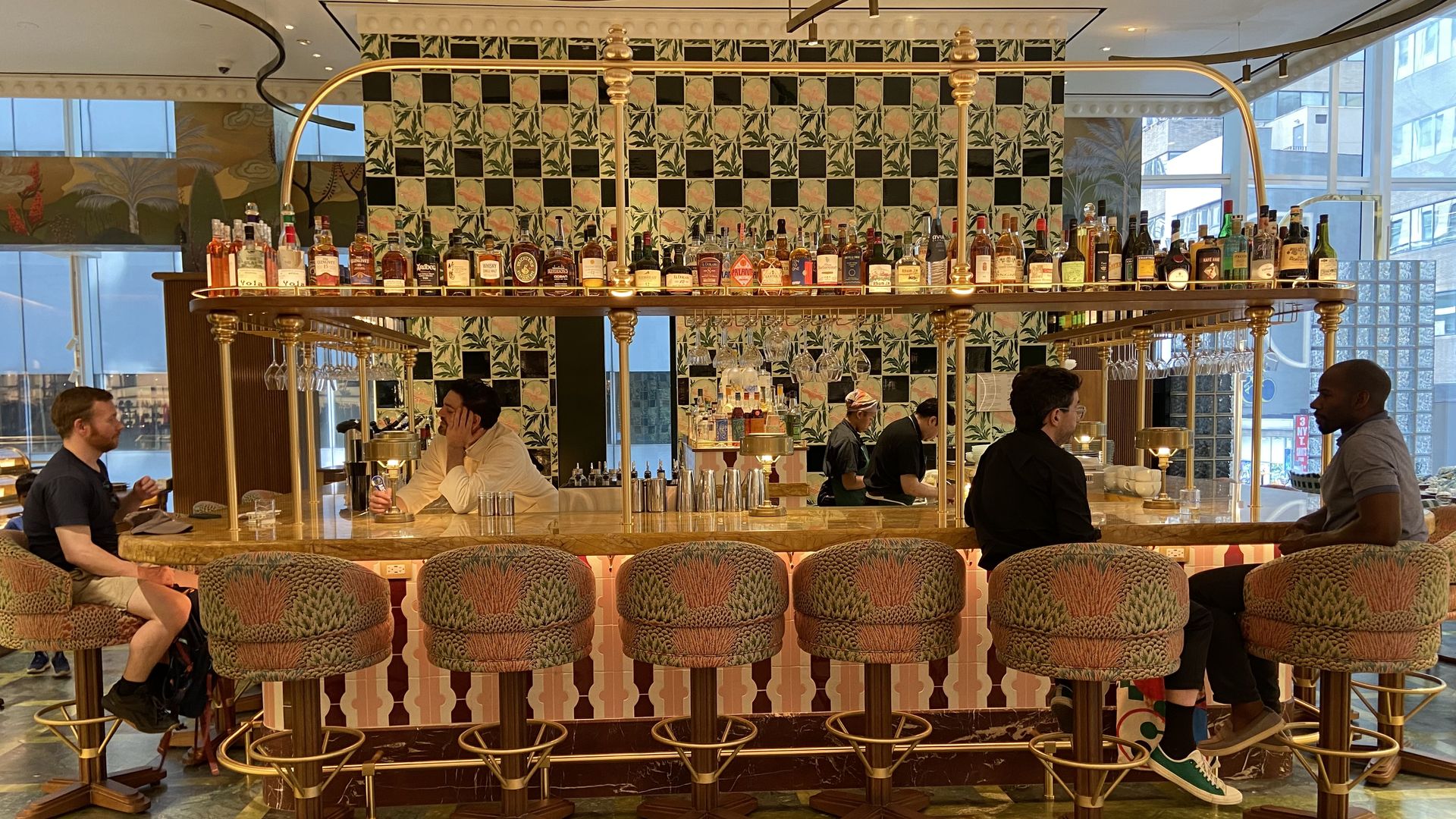 A bar with bottles of liquor and high top seating