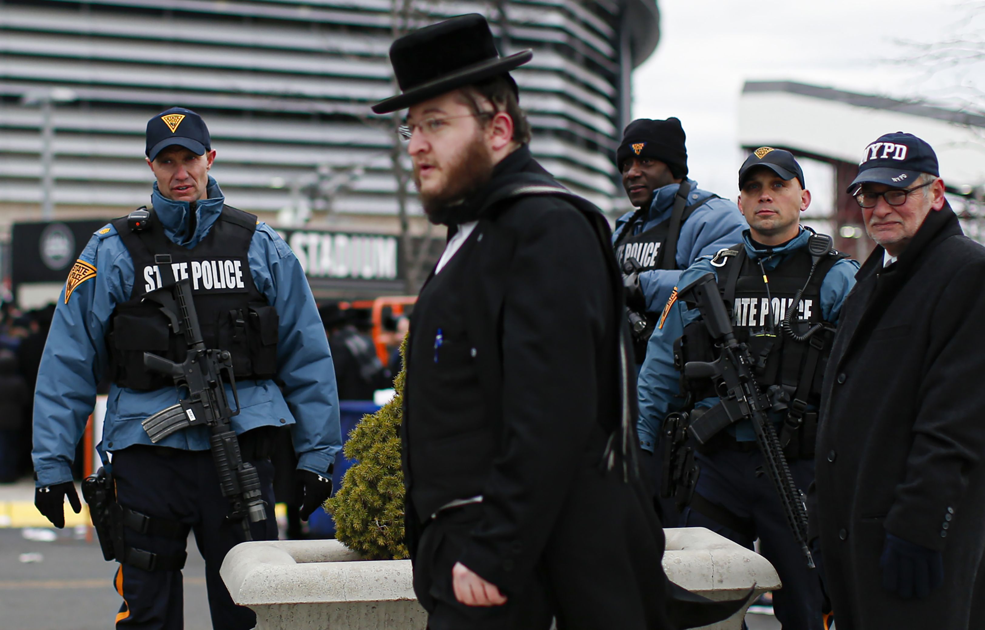New Jersey State Police officers stand guard as people congregate at the MetLife Stadium 