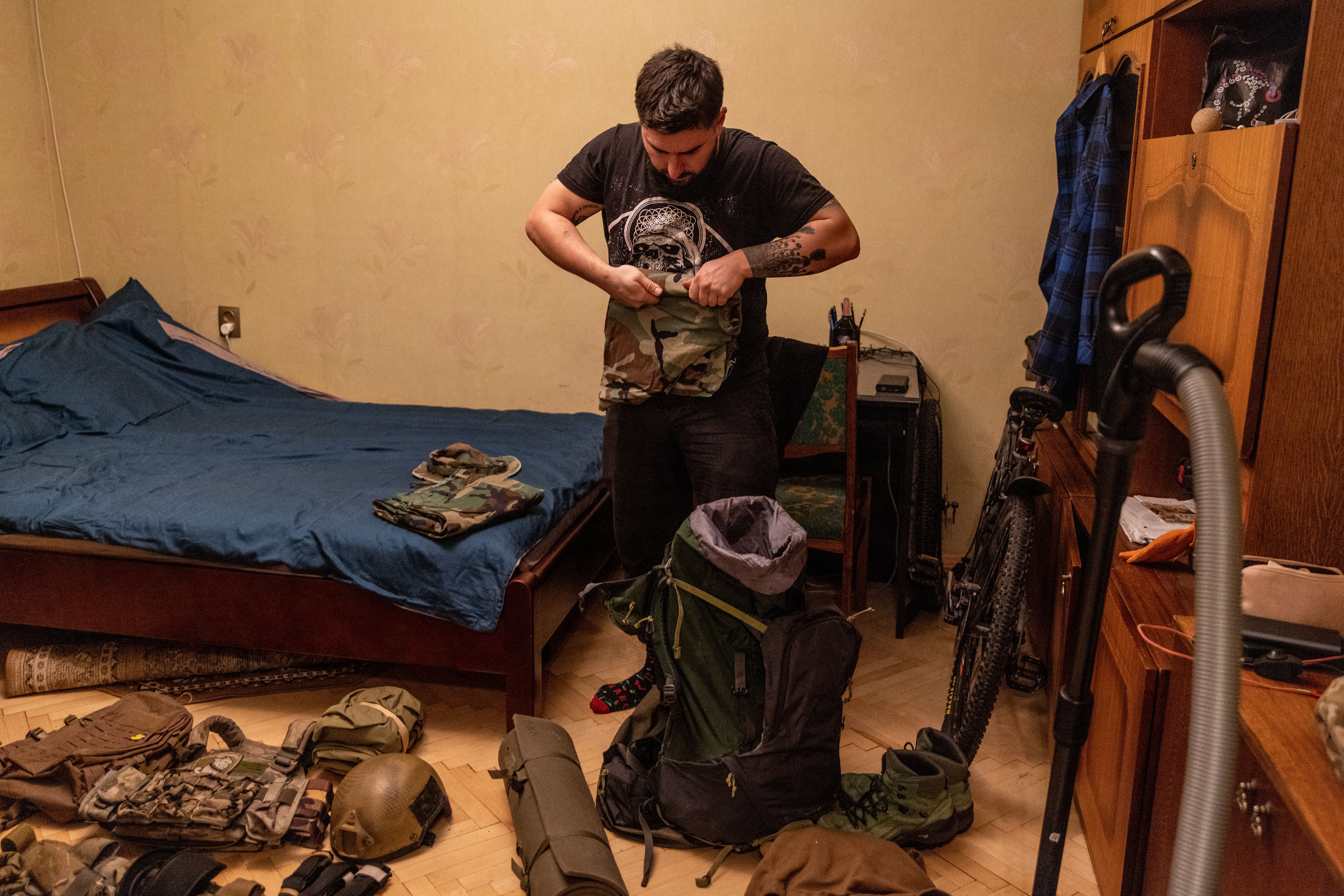 Photo of a man preparing military tactical gear in his room