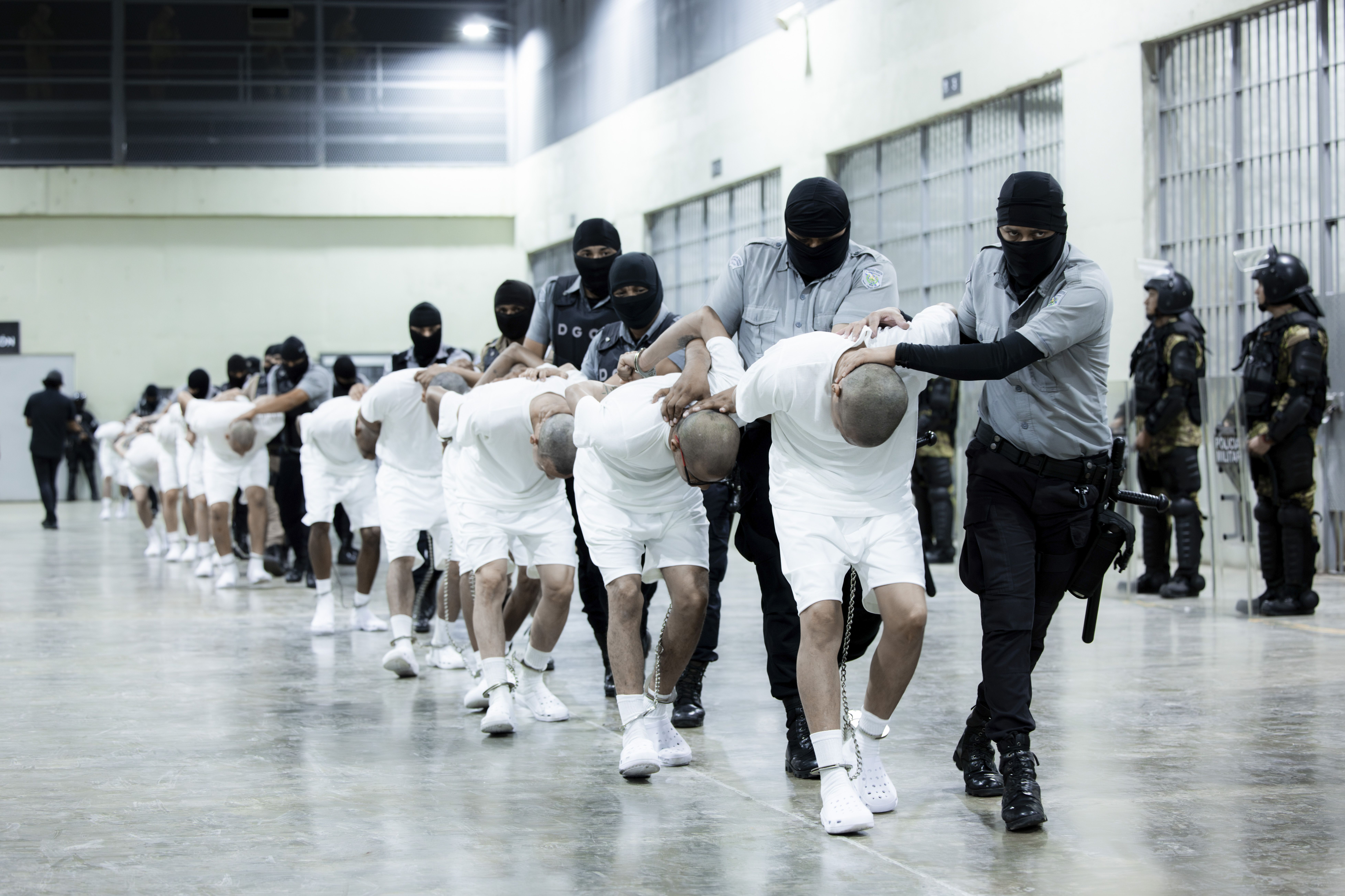 Prison guards transfer deportees from the U.S., alleged to be Venezuelan gang members, to the Terrorism Confinement Center in Tecoluca, El Salvador.