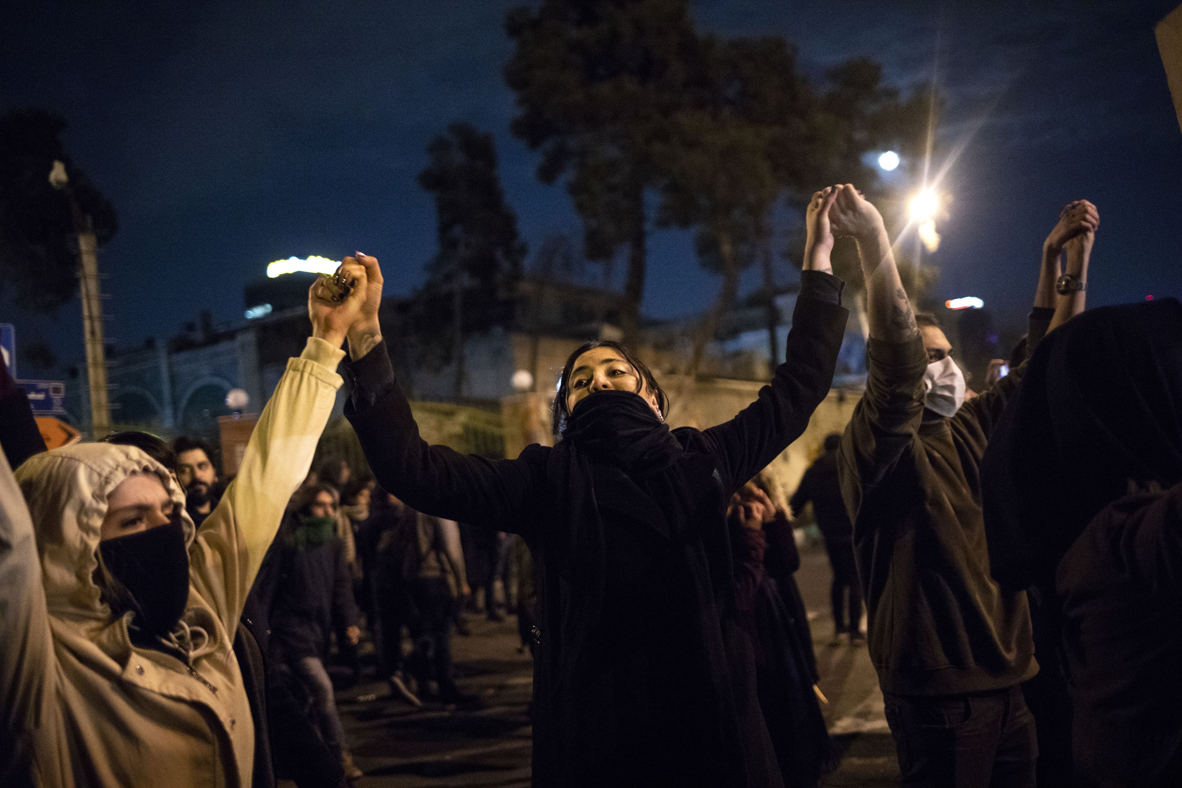  Iranians hold hands during a demonstration in front of Tehran's Amir Kabir University 