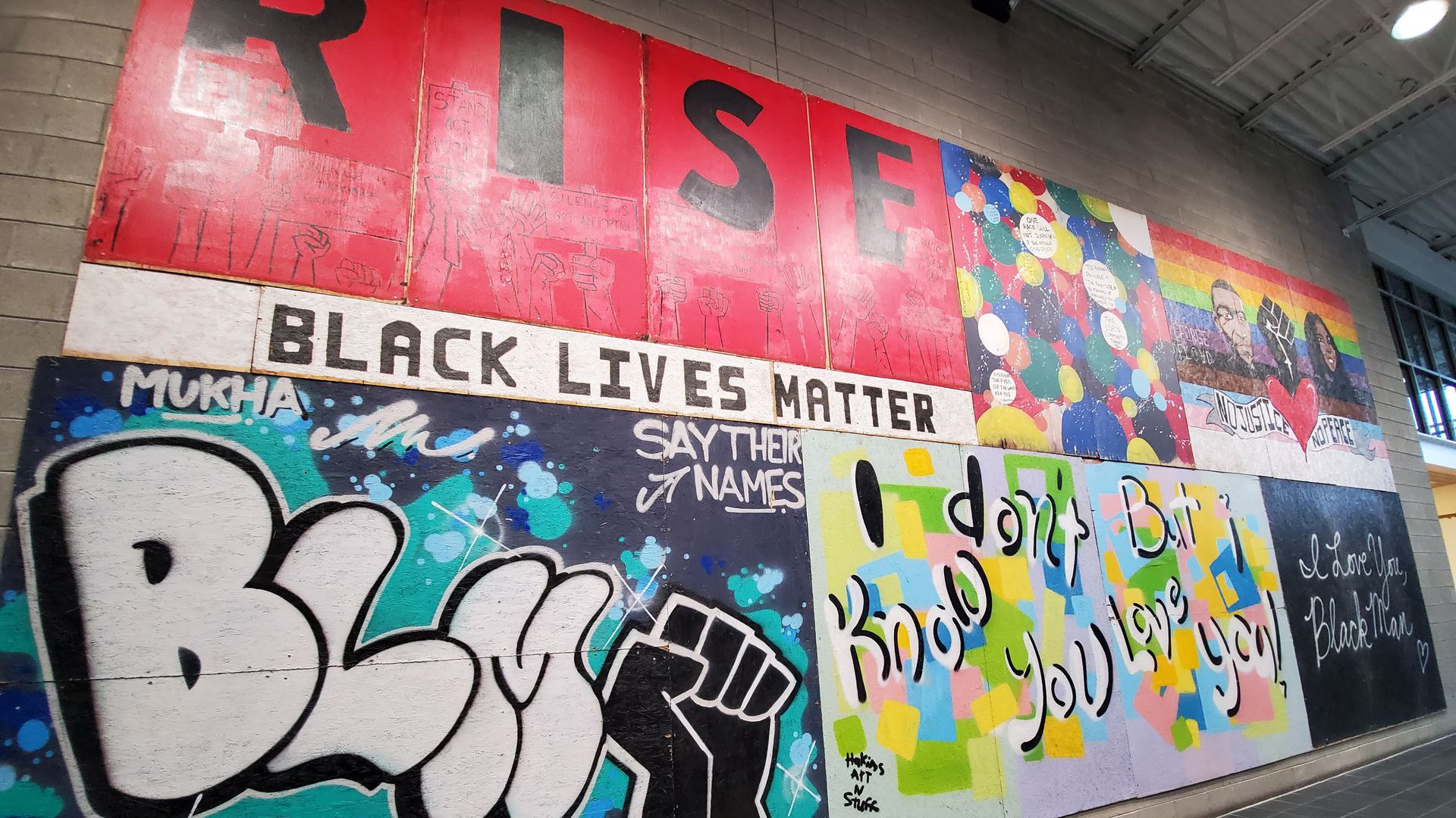 A collection of social justice murals make up a wall art exhibit.