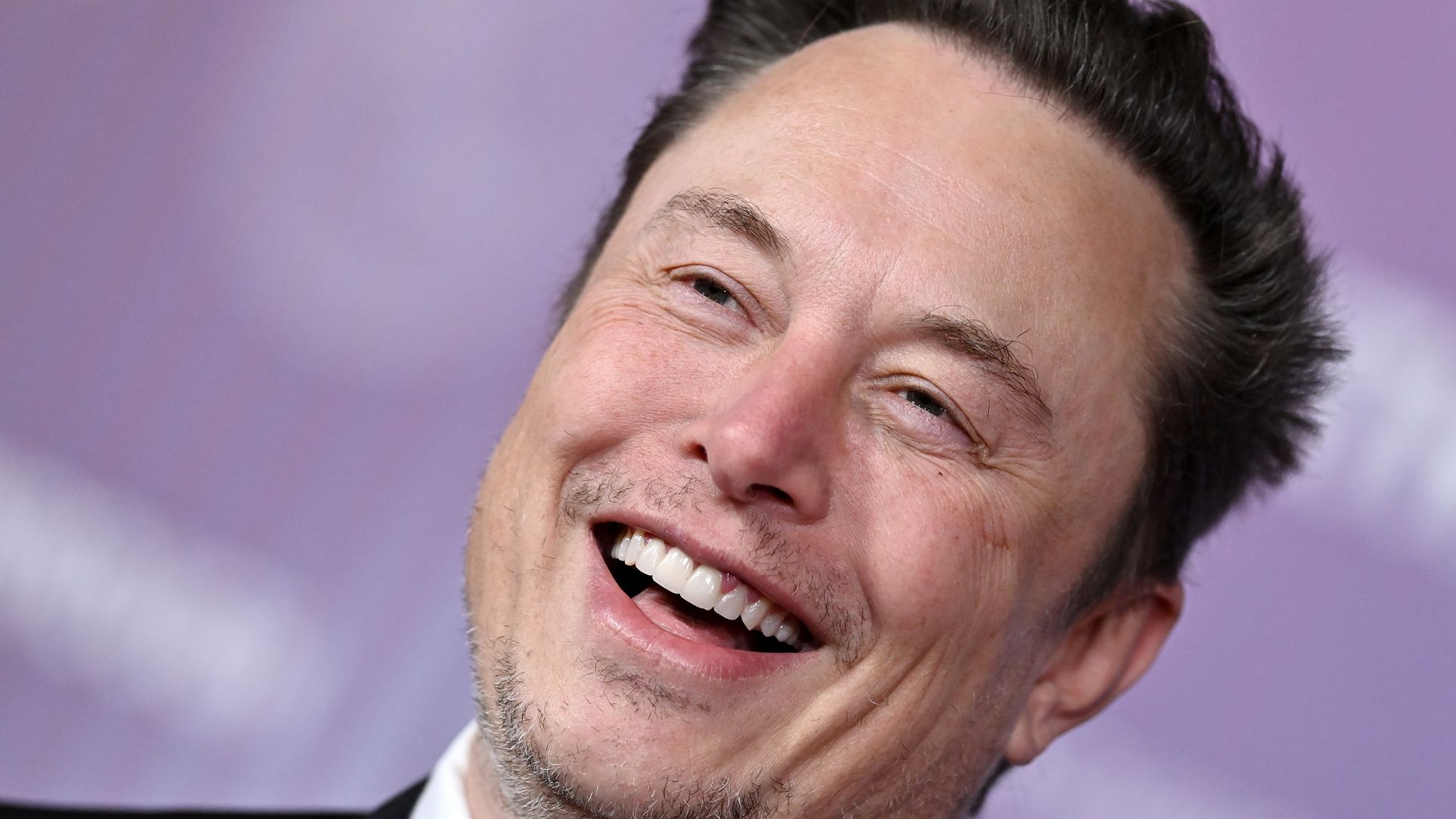 A man with gray stubble laughs