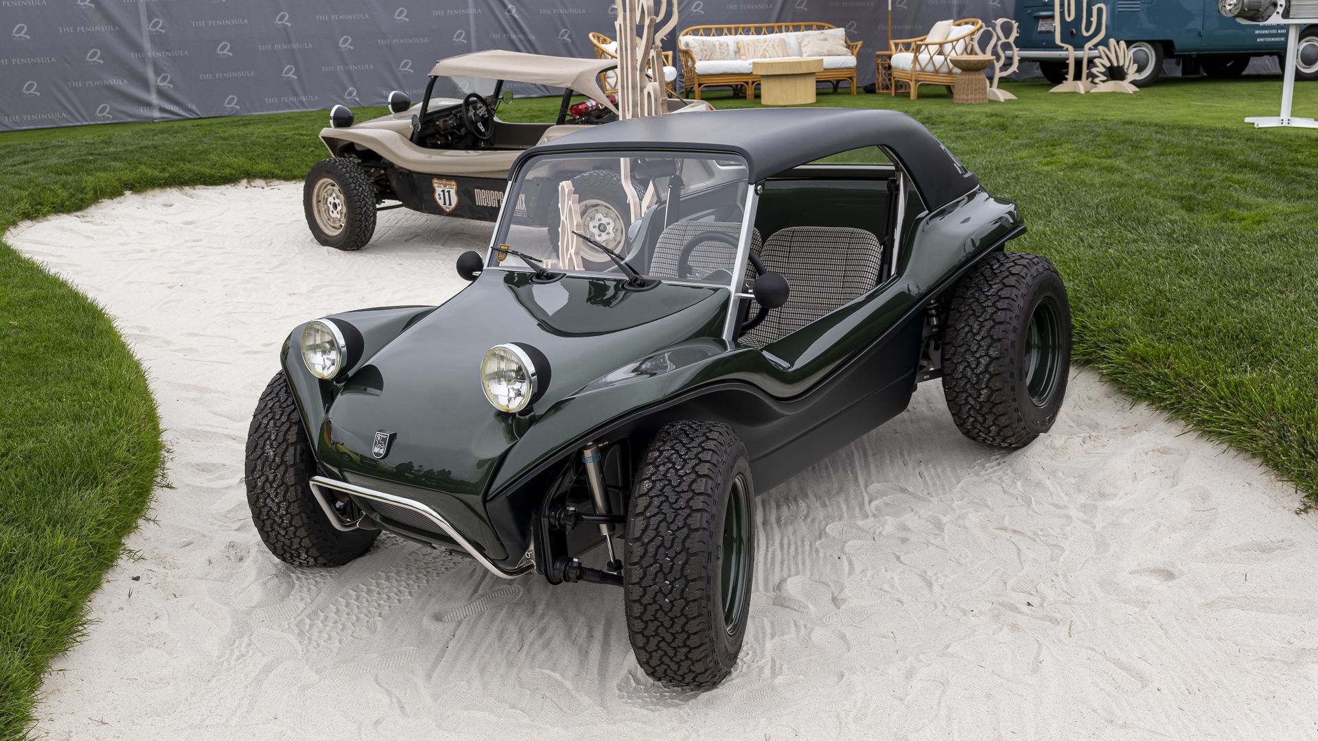 Two Meyer Manx two-seater dune buggies — one green, one tan — are photographed from above while parked in a golf course sand trap.