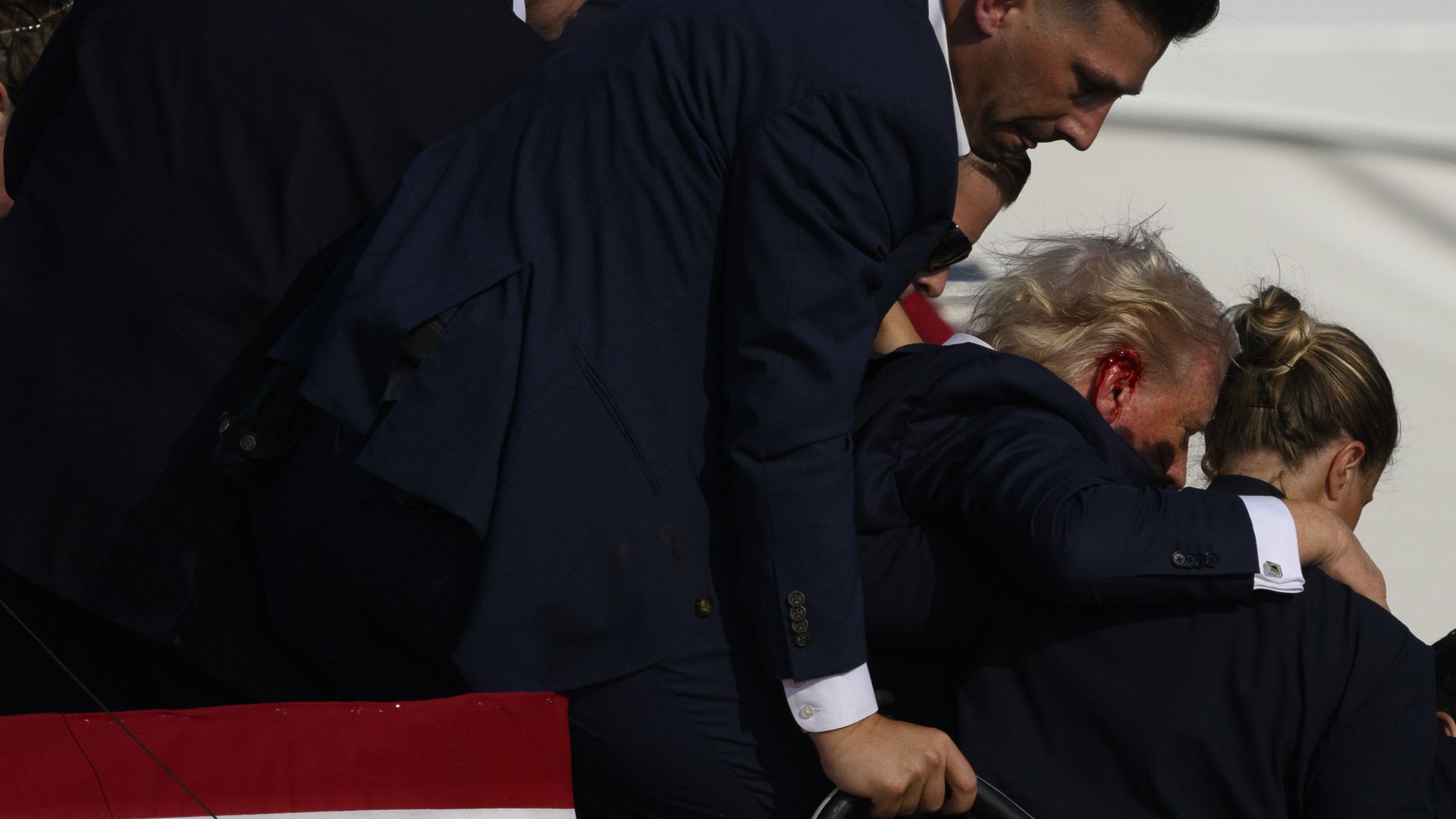 Former president Trump being escorted off stage after being shot at a rally in Butler County, PA. 