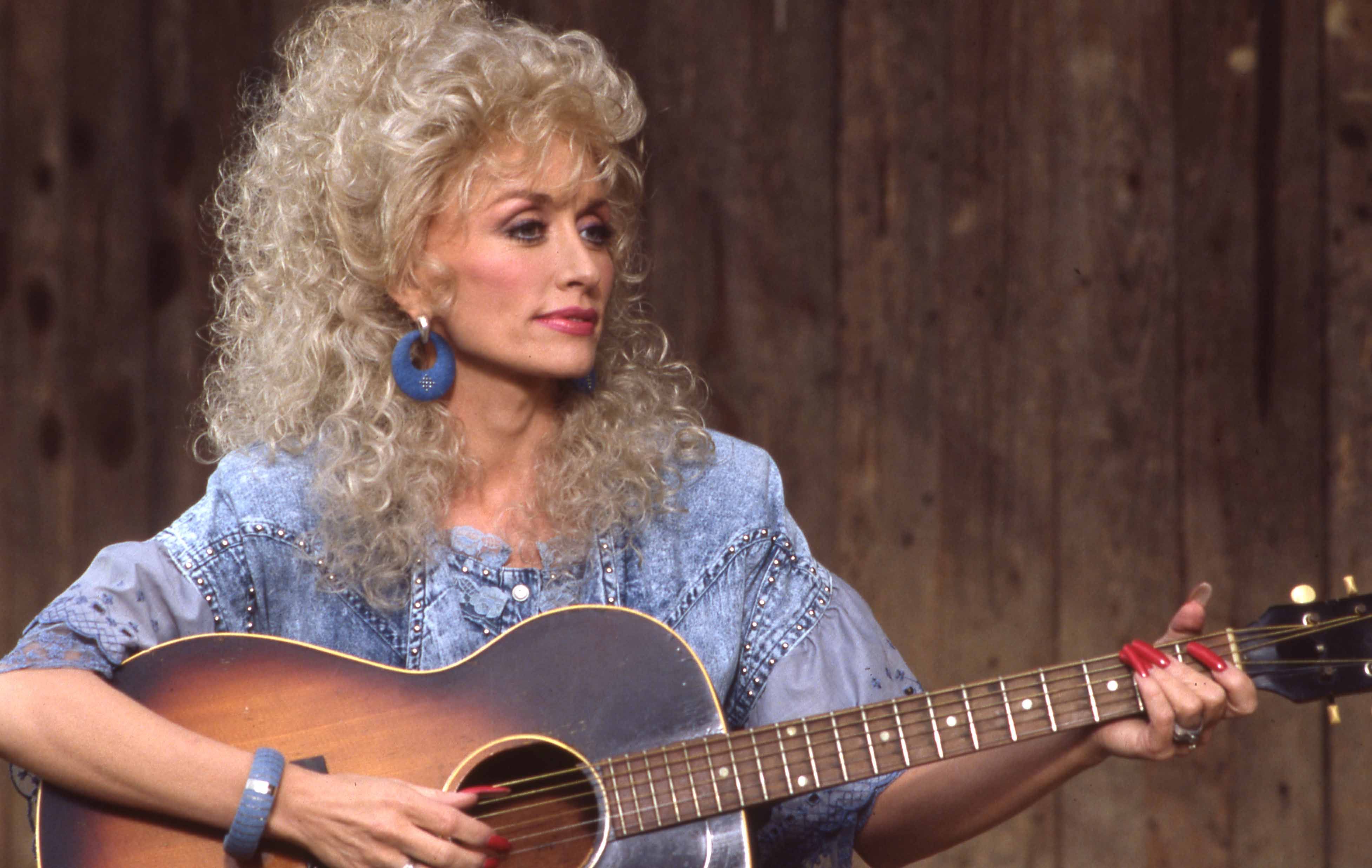 Dolly Parton performing with a guitar