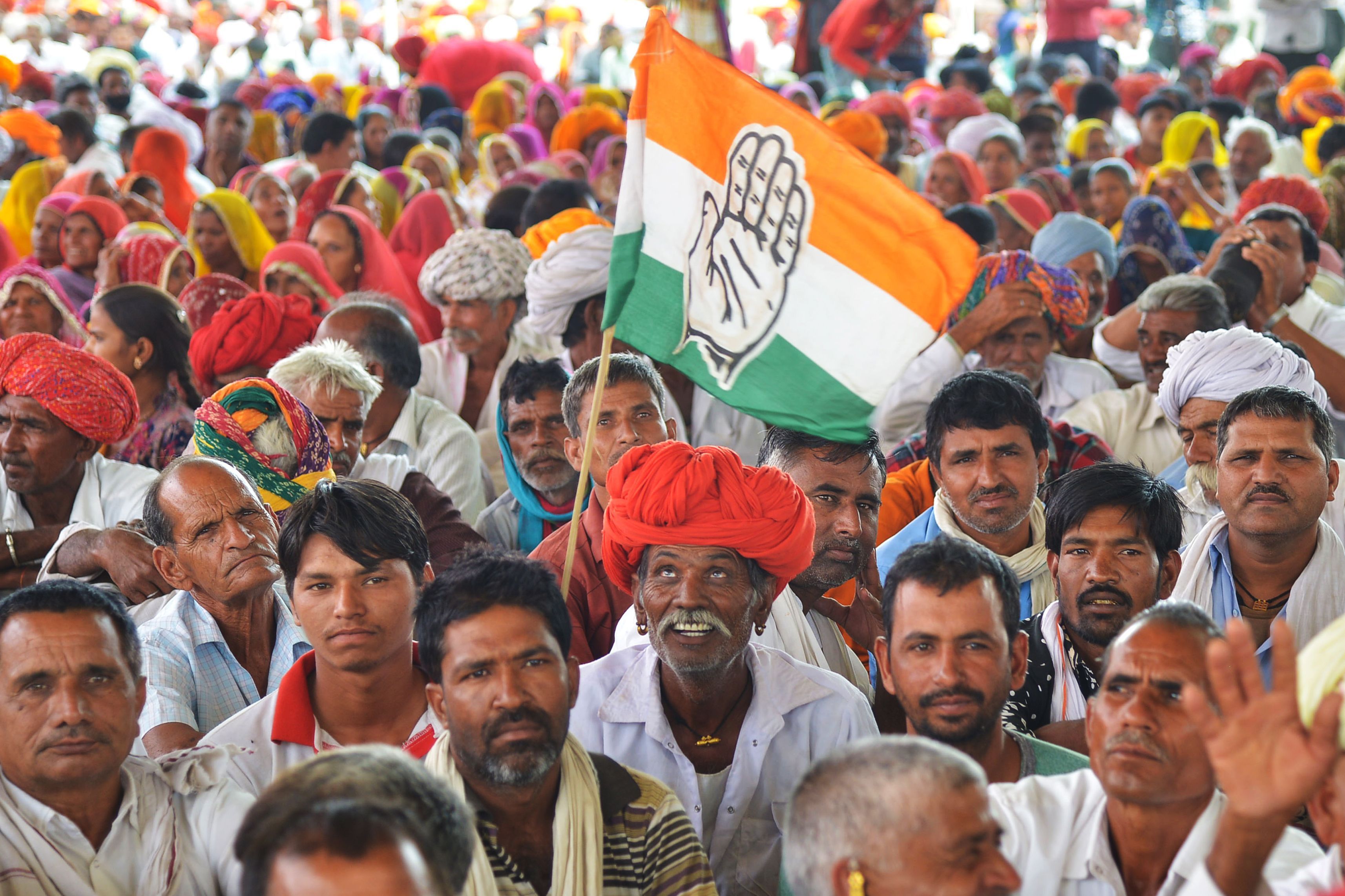 An Indian National Congress party supporter looks up to a Congress party flag during an election rally in Bandanwara, in the Indian state of Rajasthan on April 25, 2019.