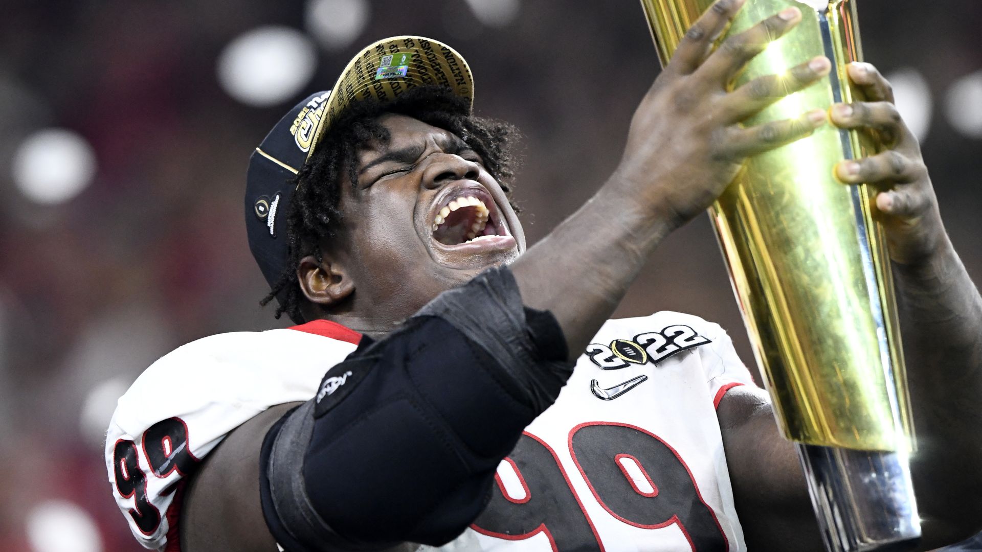 Georgia Bulldogs DL Jordan Davis (99) holds up the National Championship Trophy.