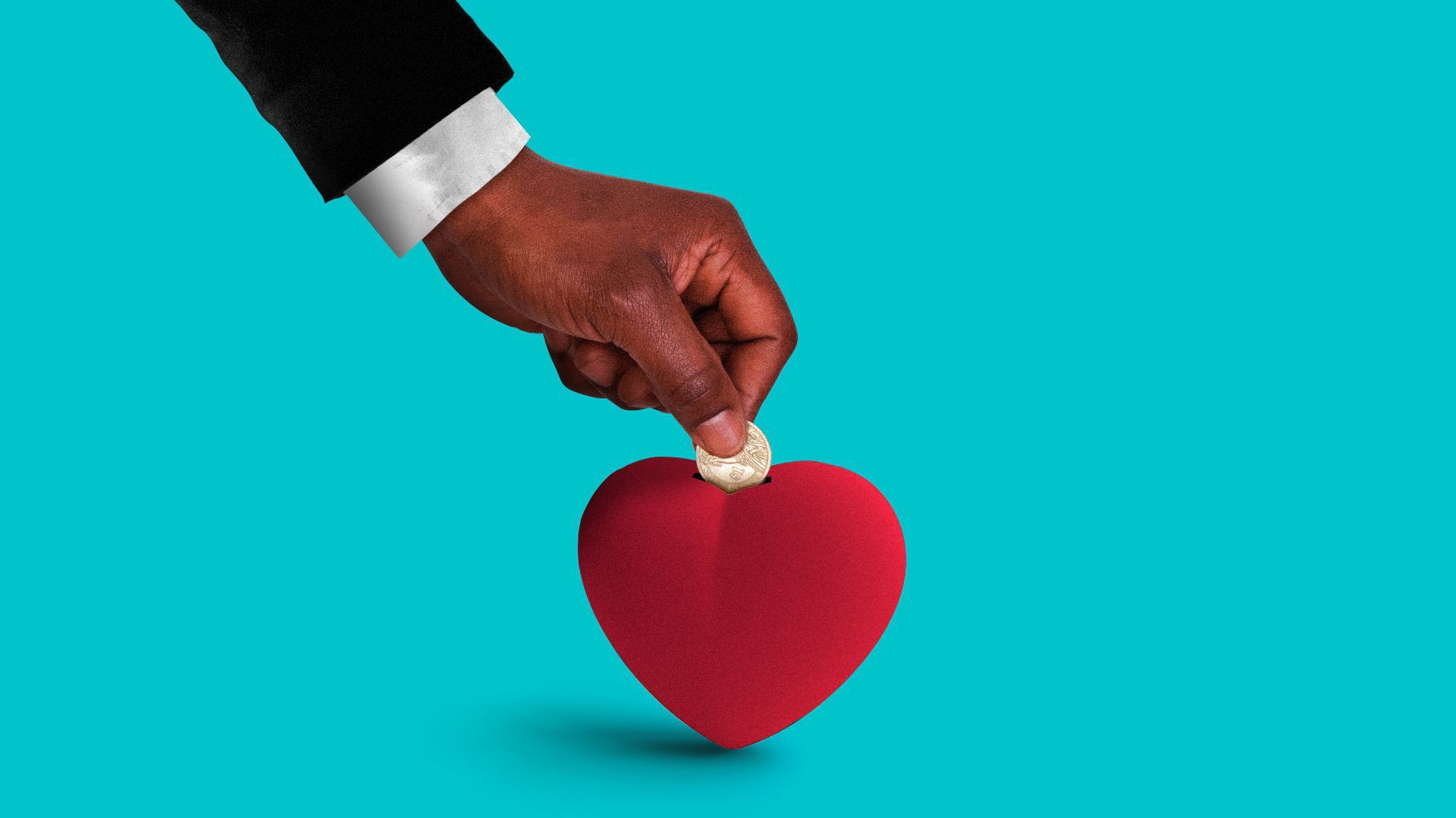 Hand placing money in a heart piggy bank