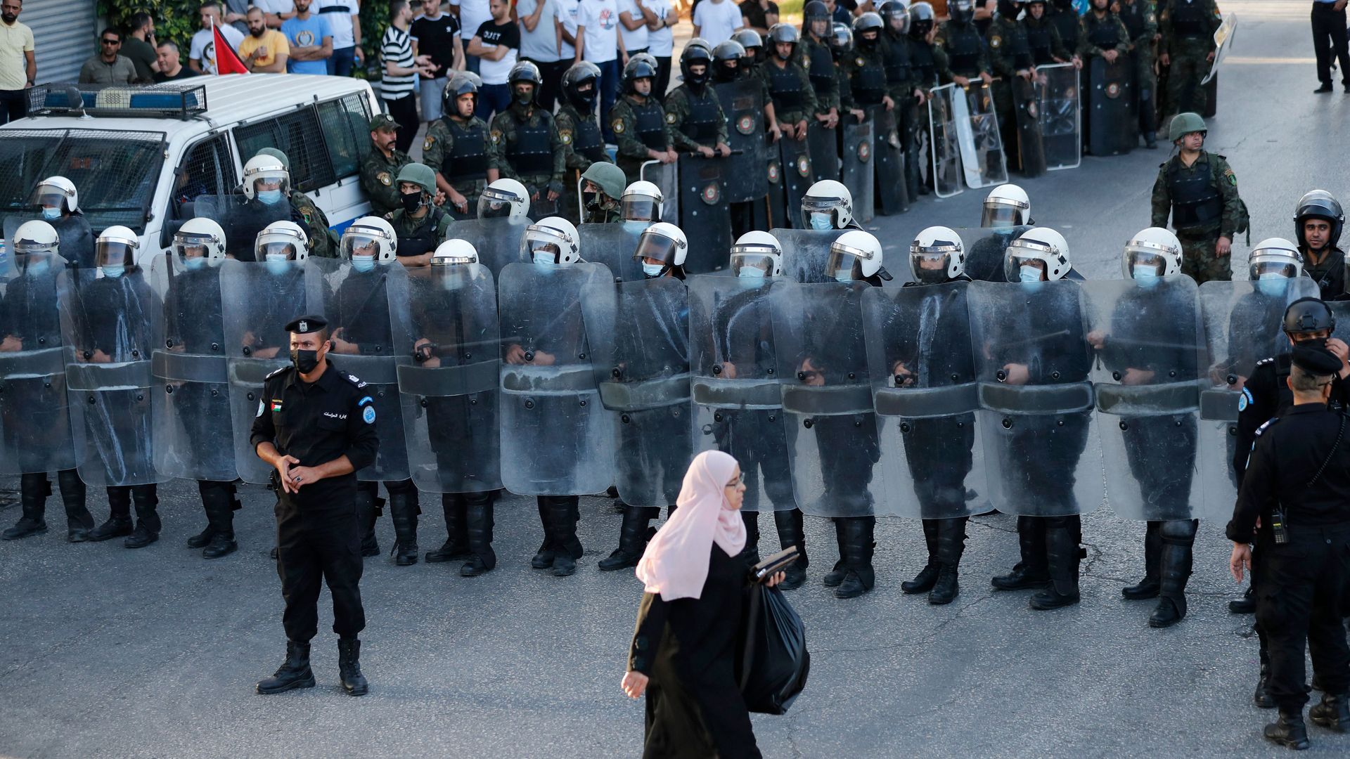 Members of the Palestinian Authority security forces block a road as demonstrators rally in Ramallah city in the occupied West Bank on July 3, 2021,