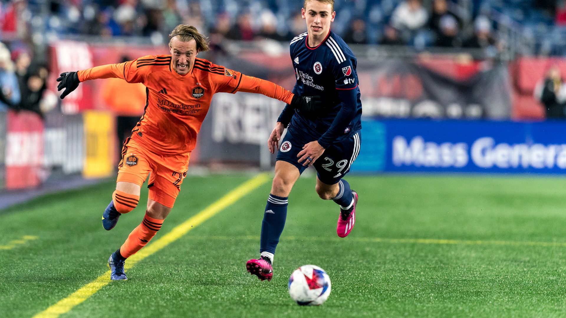 A Houston Dynamo player fights off a defender and runs after a loose soccer ball during a match