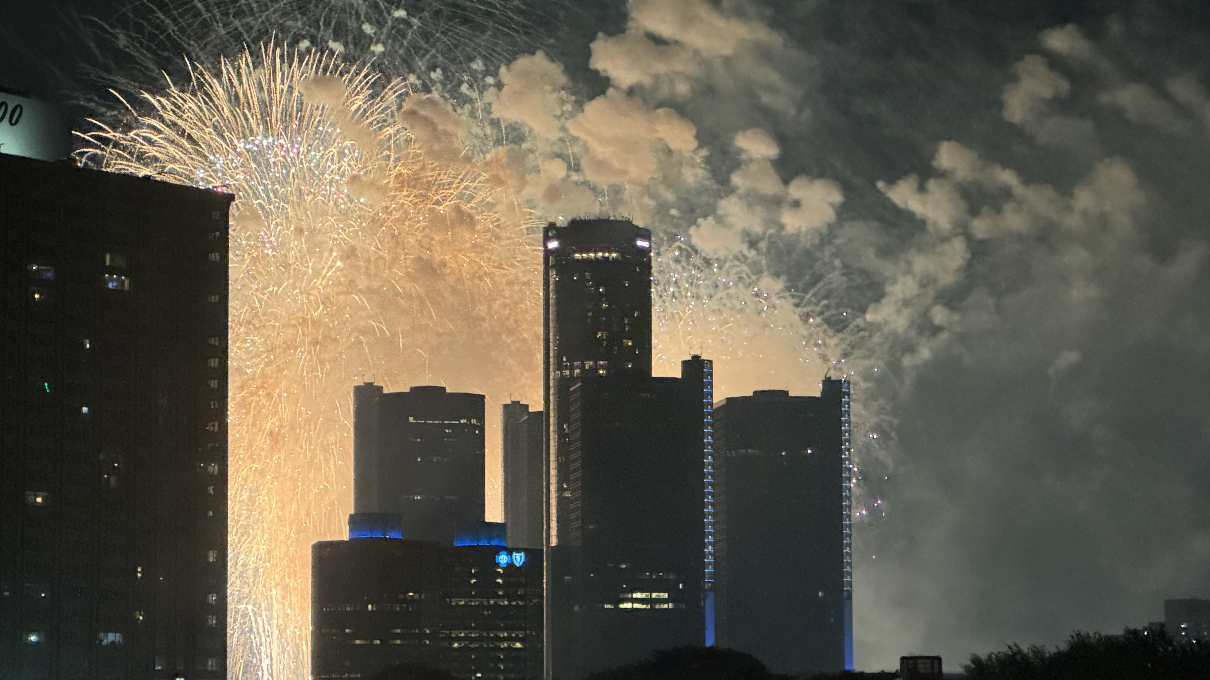 Fireworks flash behind GM's Ren Cen seen from Lafayette Towers. Photo: Samuel Robinson/Axios