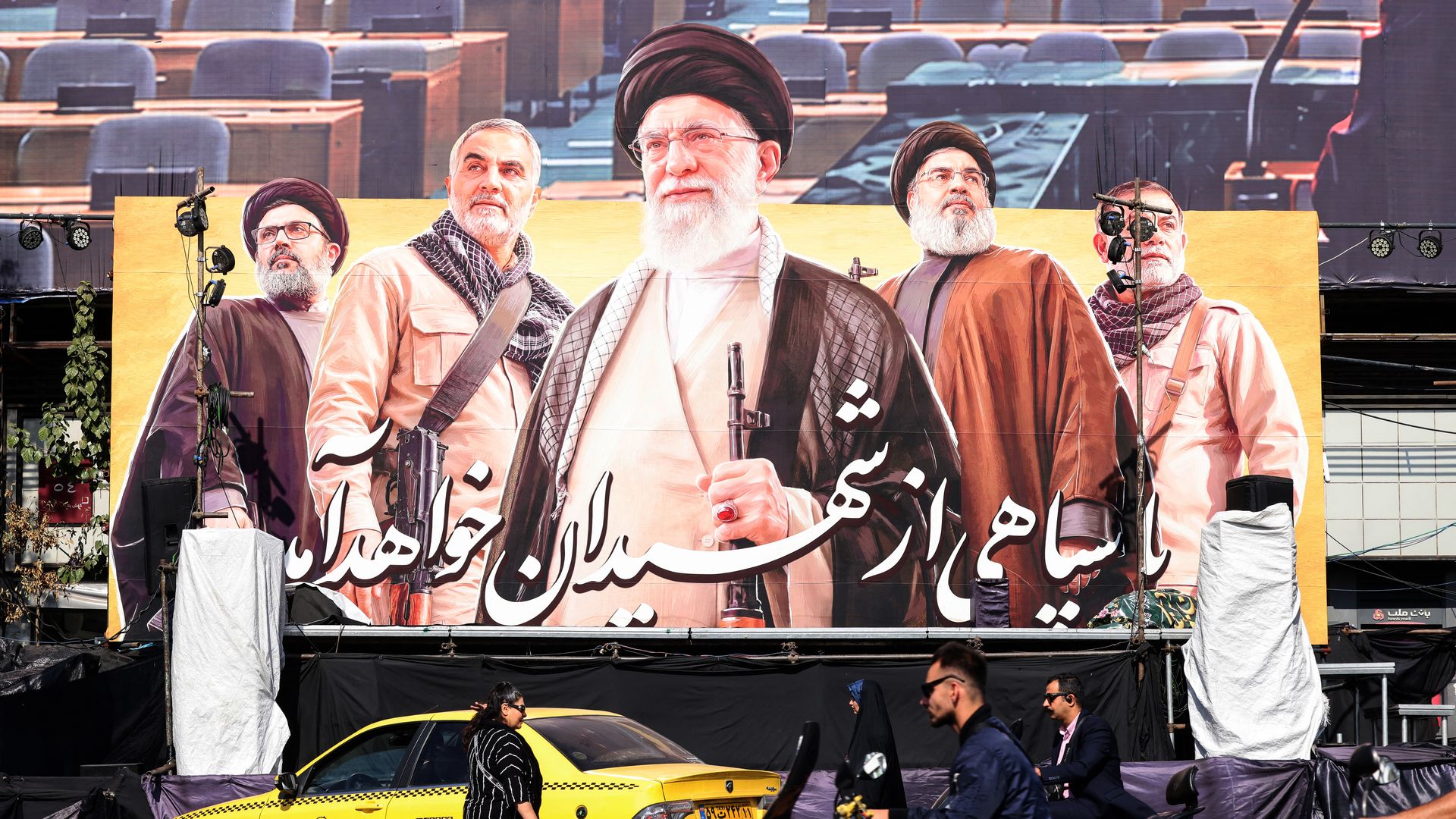 Commuters ride past a large billboard depicting slain Supreme Leader Ayatollah Ali Khamenei in Tehran this week.