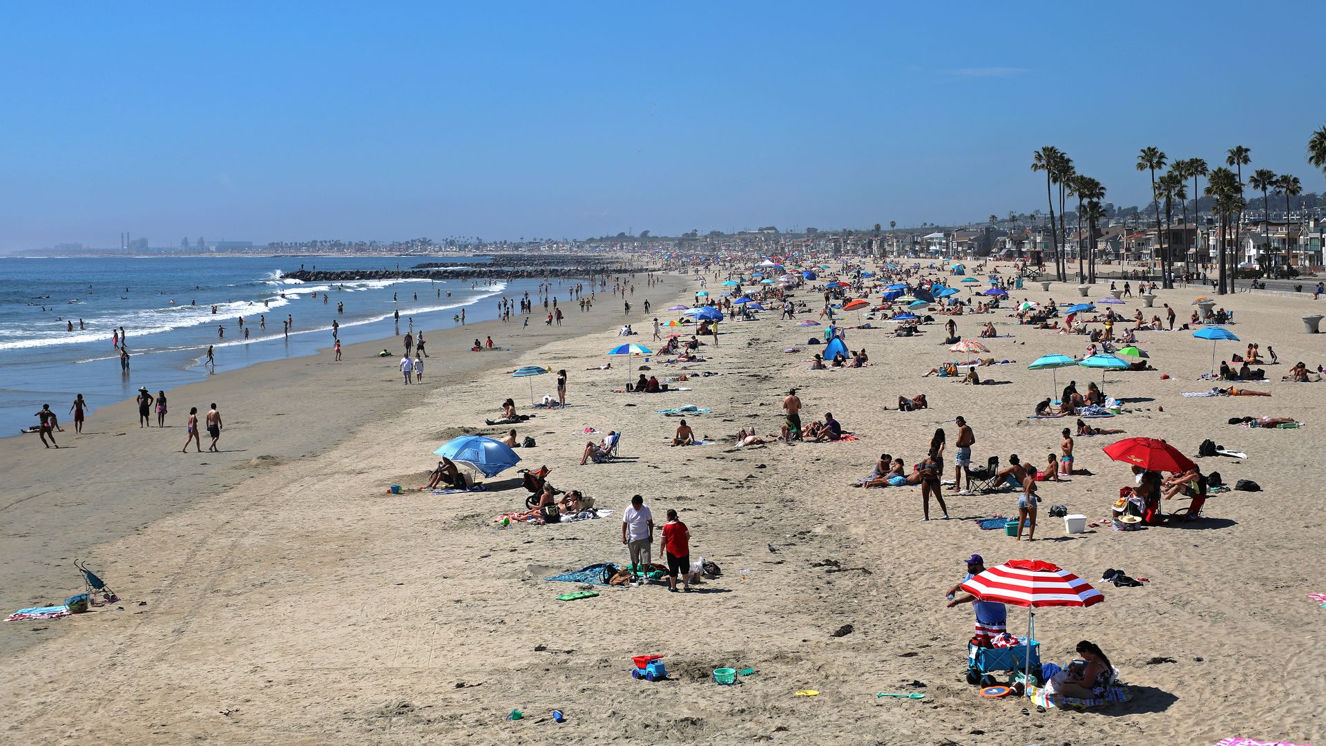 People are seen gathering on the beach north of Newport Beach Pier on April 25, 2020 in Newport Beach, California.