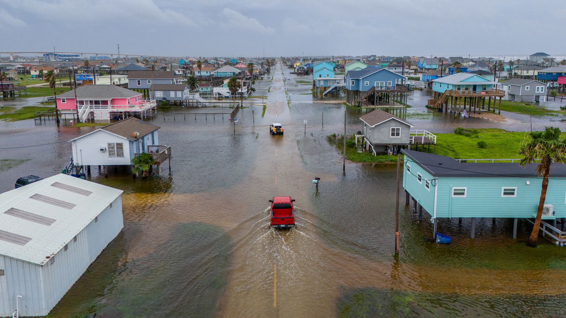  In this aerial image, vehicles drive through flooded neighborhoods on June 19, 2024 in Surfside Beach, Texas. 