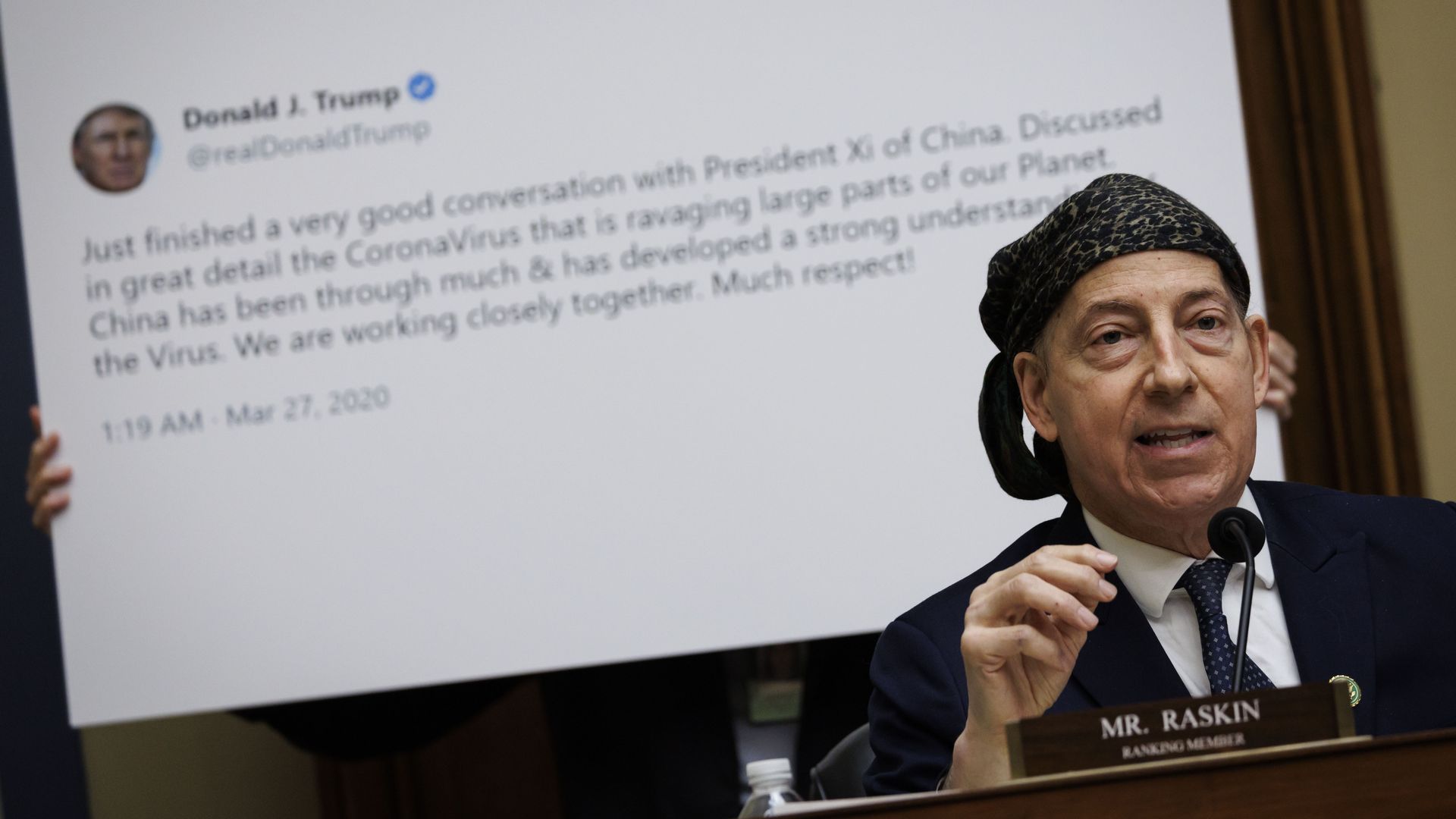 Rep. Jamie Raskin, wearing a blue suit, white shirt, a blue tie and a bandana, speaks at a committee hearing in front of a blowup photo of a Trump tweet.