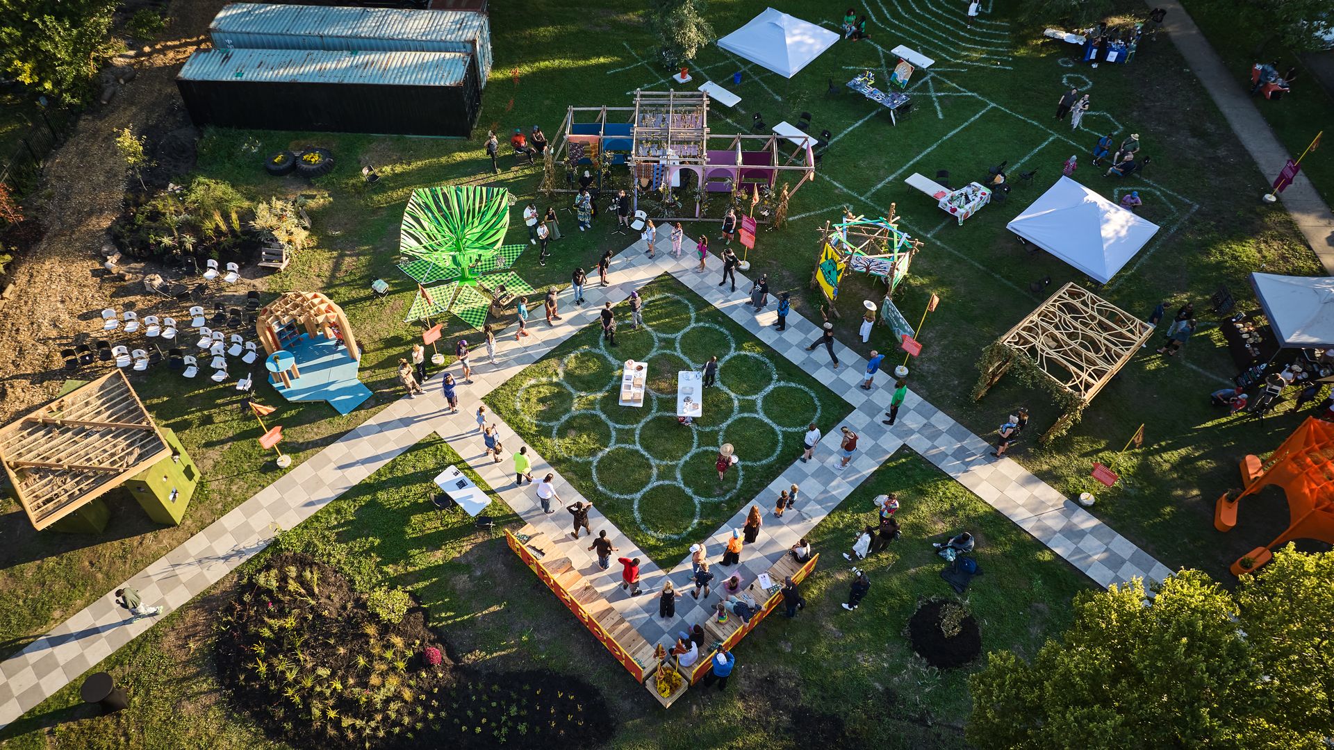 An aerial photo of a green lawn with a wooden path around a square.