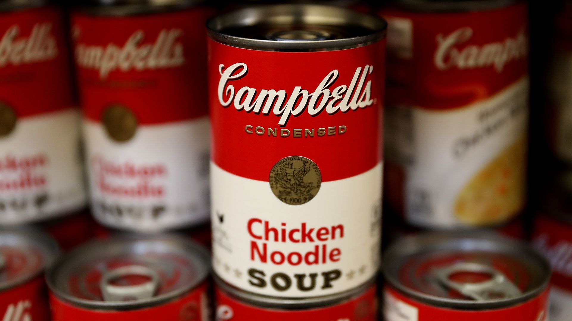 Cans of Campbell's soup are displayed on a shelf