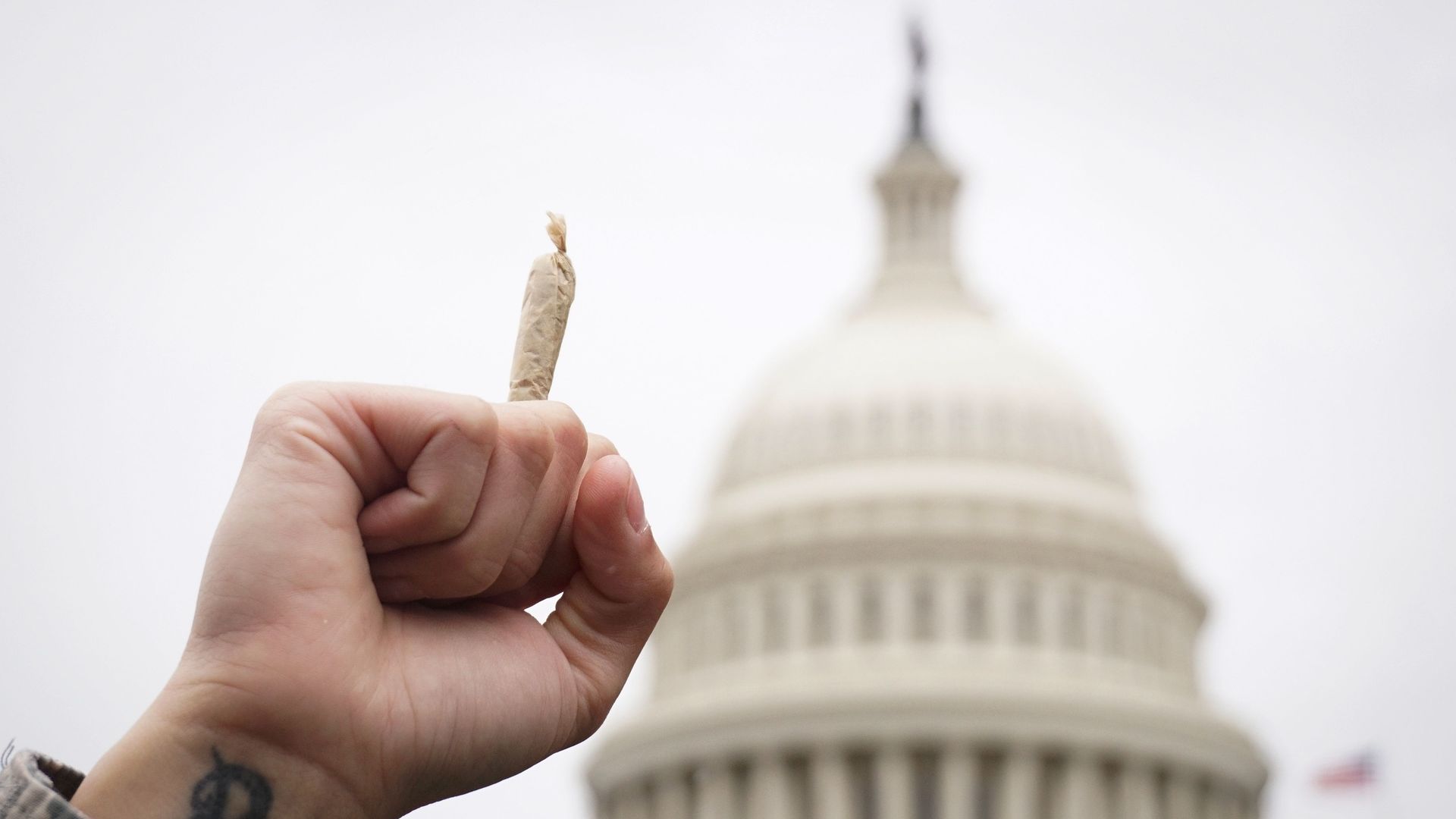 A pro-cannabis activist holds up a marijuana cigarette during a rally on Capitol Hill on April 24, 2017