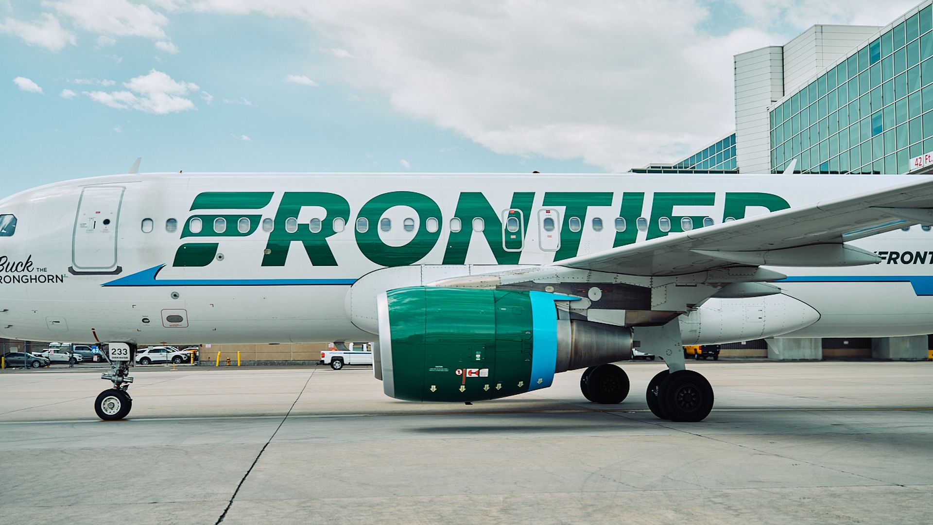 A Frontier airplane in profile on a tarmac
