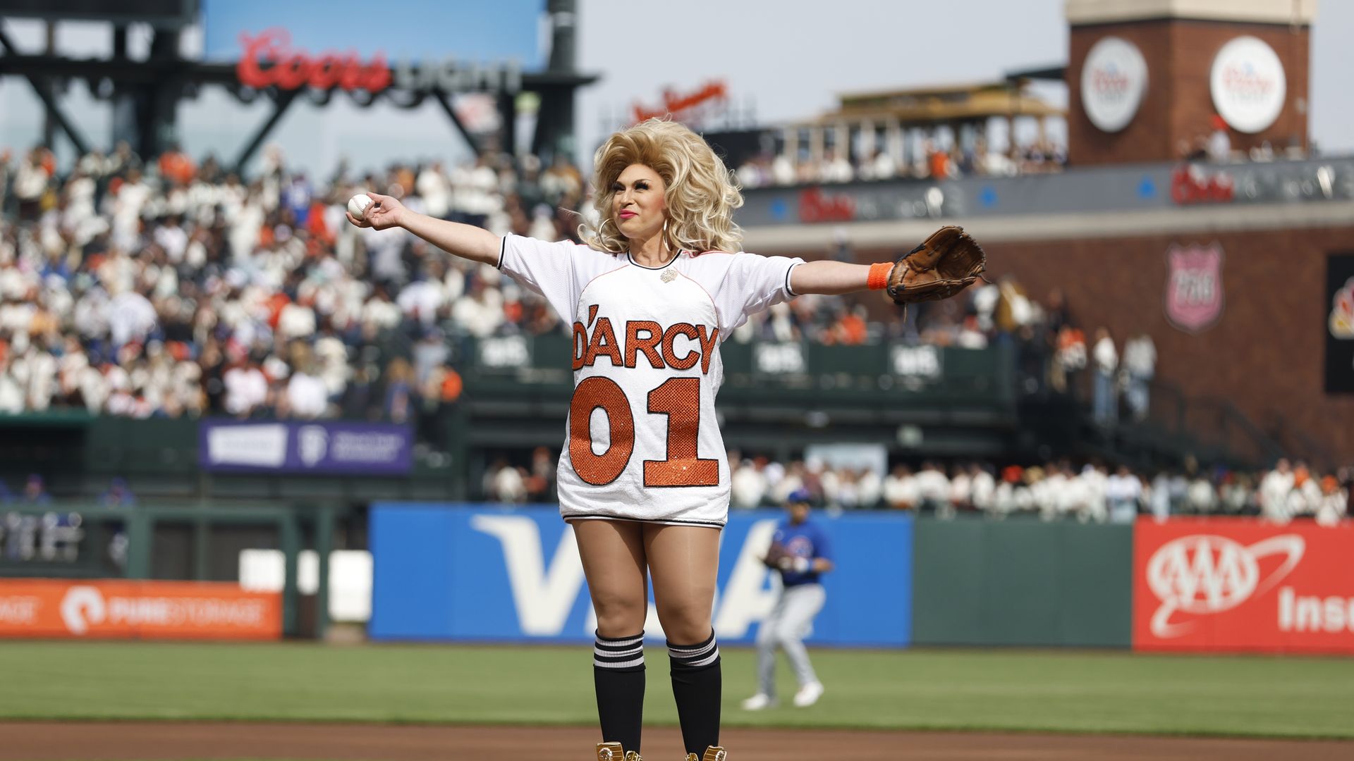 Photo of D'Arcy Drollinger holding her arms out as she prepares to pitch at a Giants game