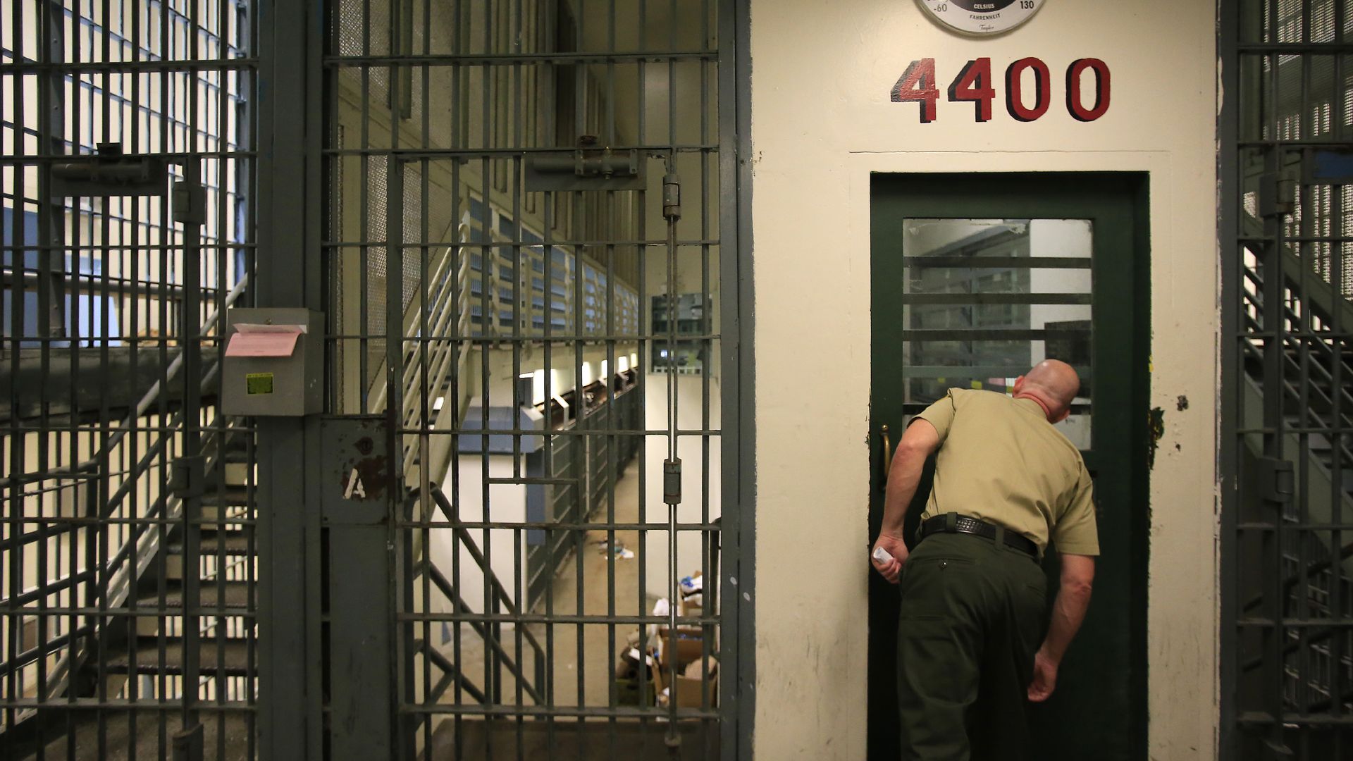 A sheriff peers into jail cells. 